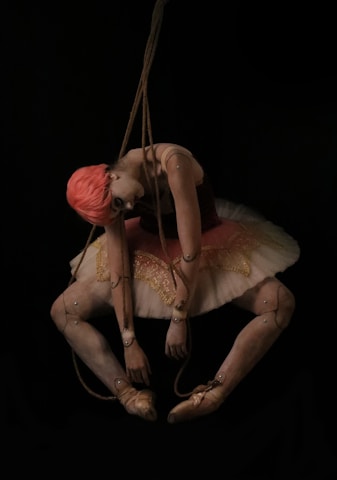 A ballerina hanging from a string in the dark