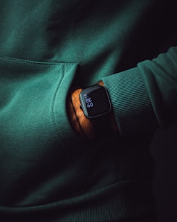 A person in a green sweater with a smart watch on their wrist