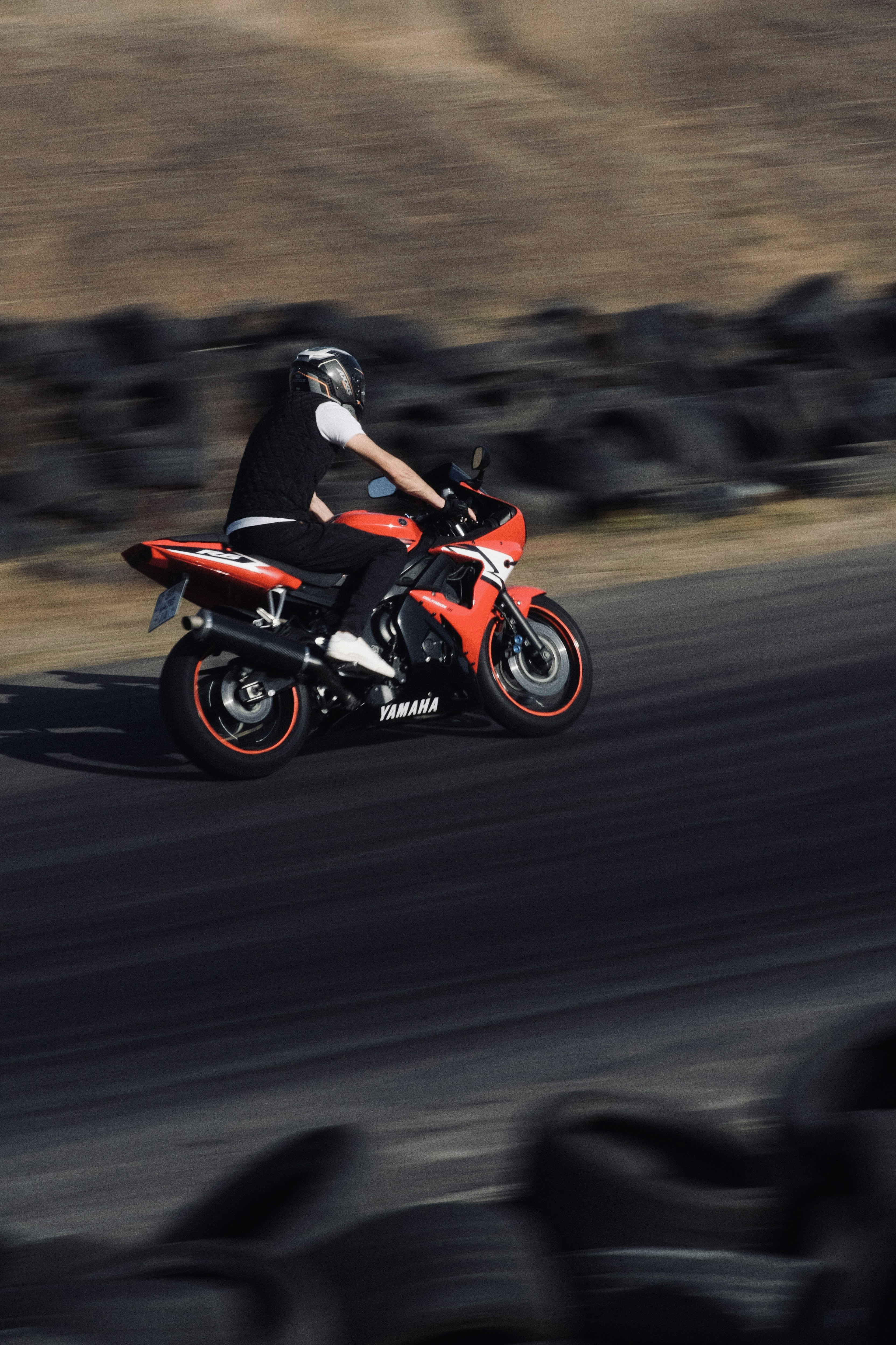 A man riding a red motorcycle down a curvy road