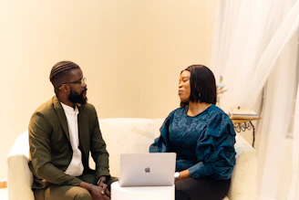 A man and a woman sitting on a couch talking