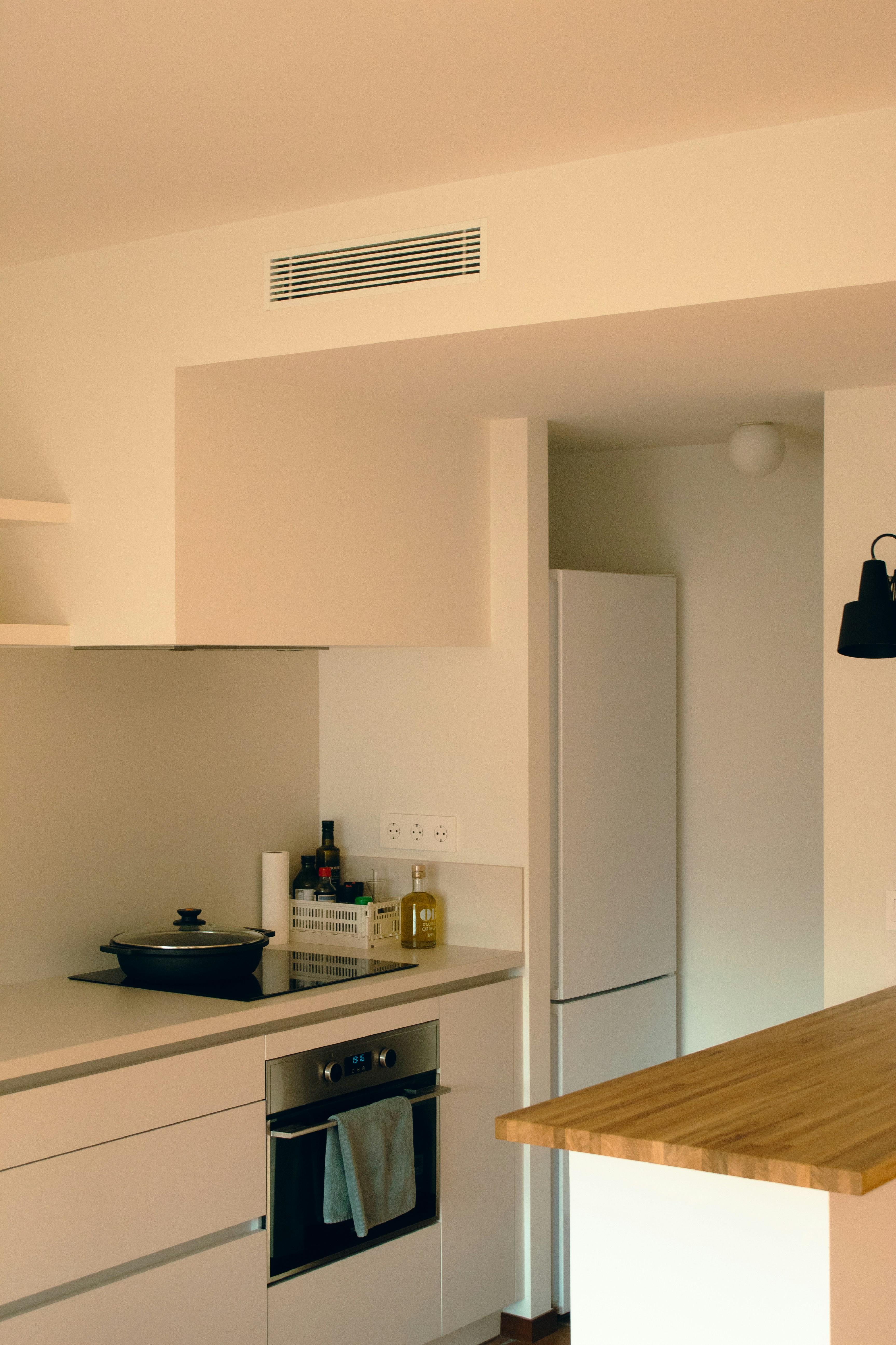 A white kitchen with a wooden counter top