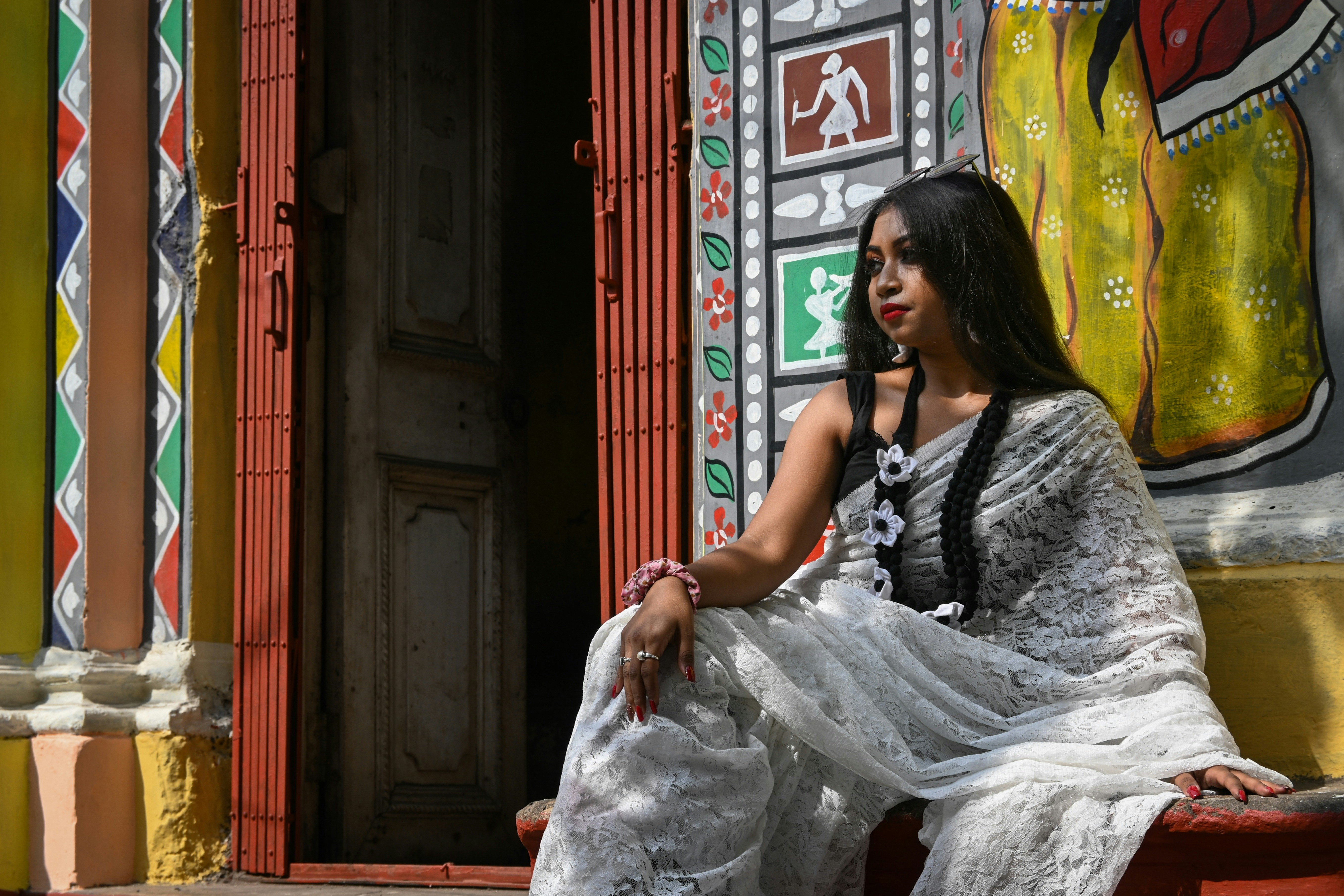 A woman sitting on a bench in front of a building