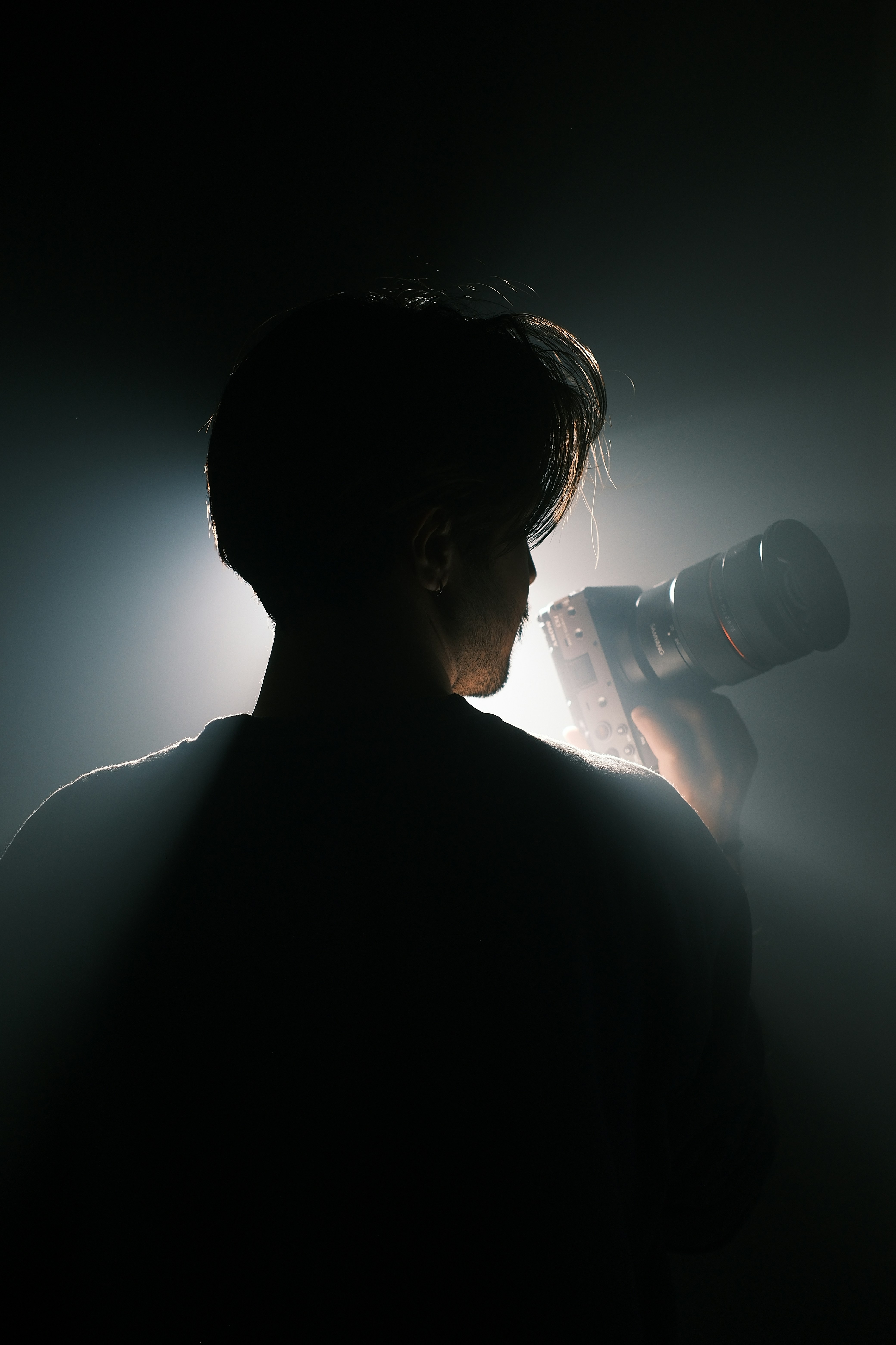 A man drinking from a bottle in the dark