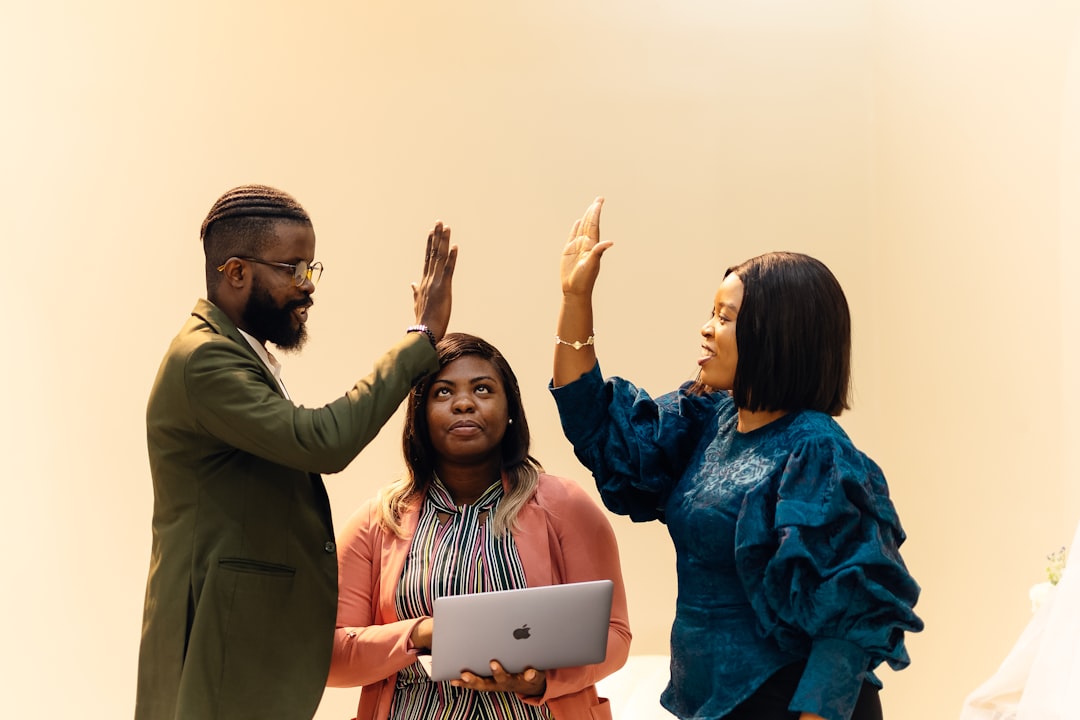 A group of people standing next to each other, A team of three people, a man and two women standing together. Find more afro-centric images at www.ninthgrid.com