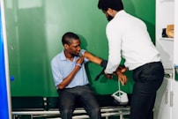 A man helping another man put on a tie