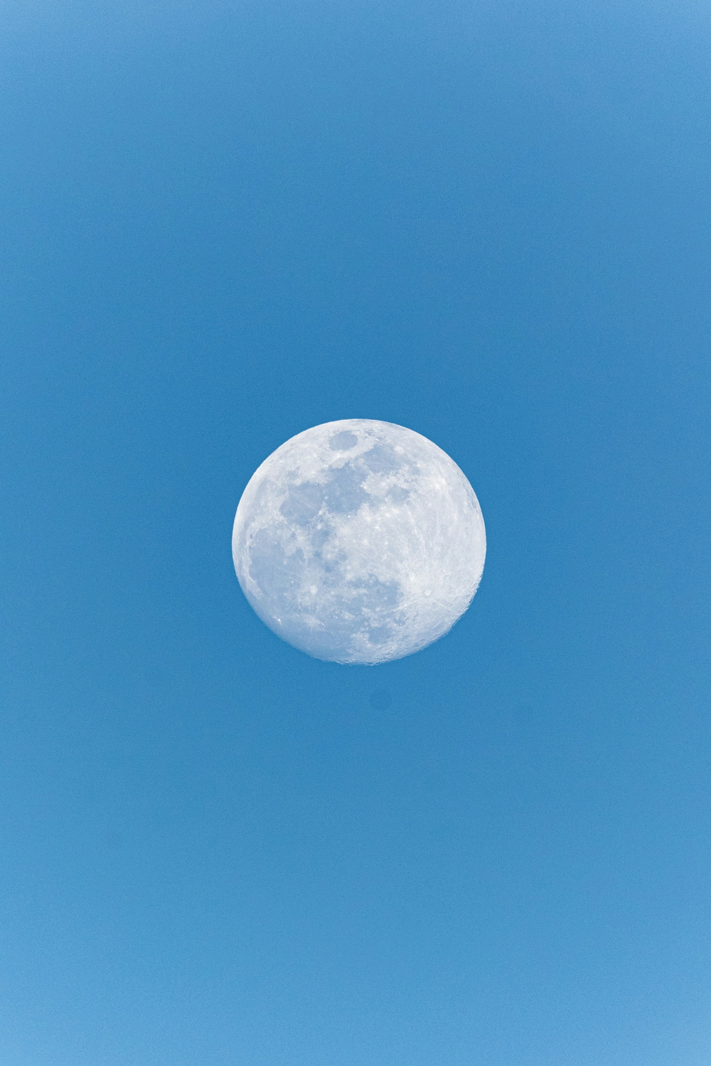 Una luna piena in un cielo azzurro e limpido