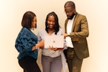 A group of people standing around a laptop computer