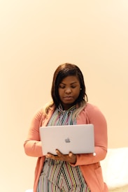 A woman standing in front of a laptop computer