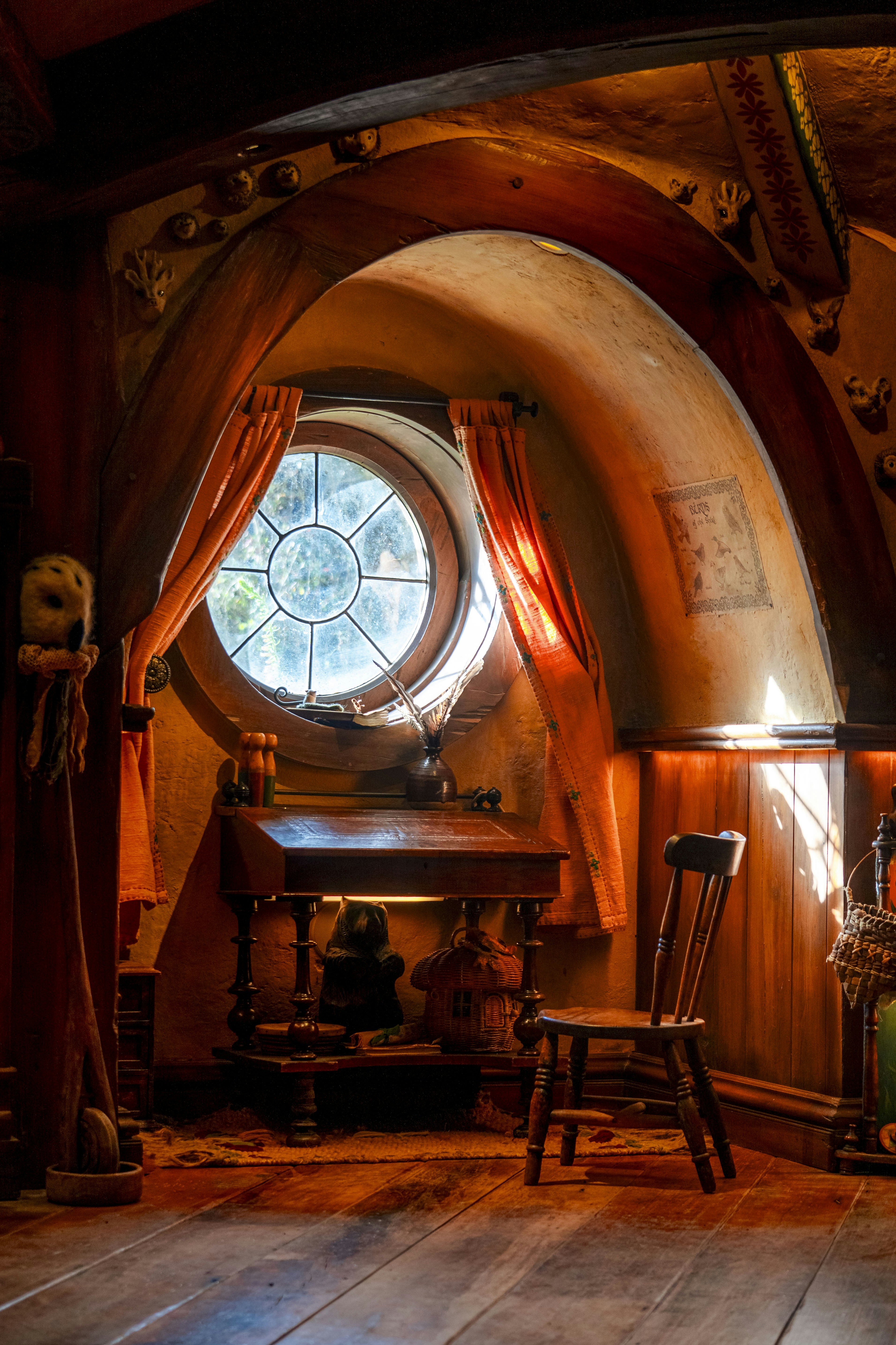 Ein Zimmer mit einem runden Fenster und einem Holzboden