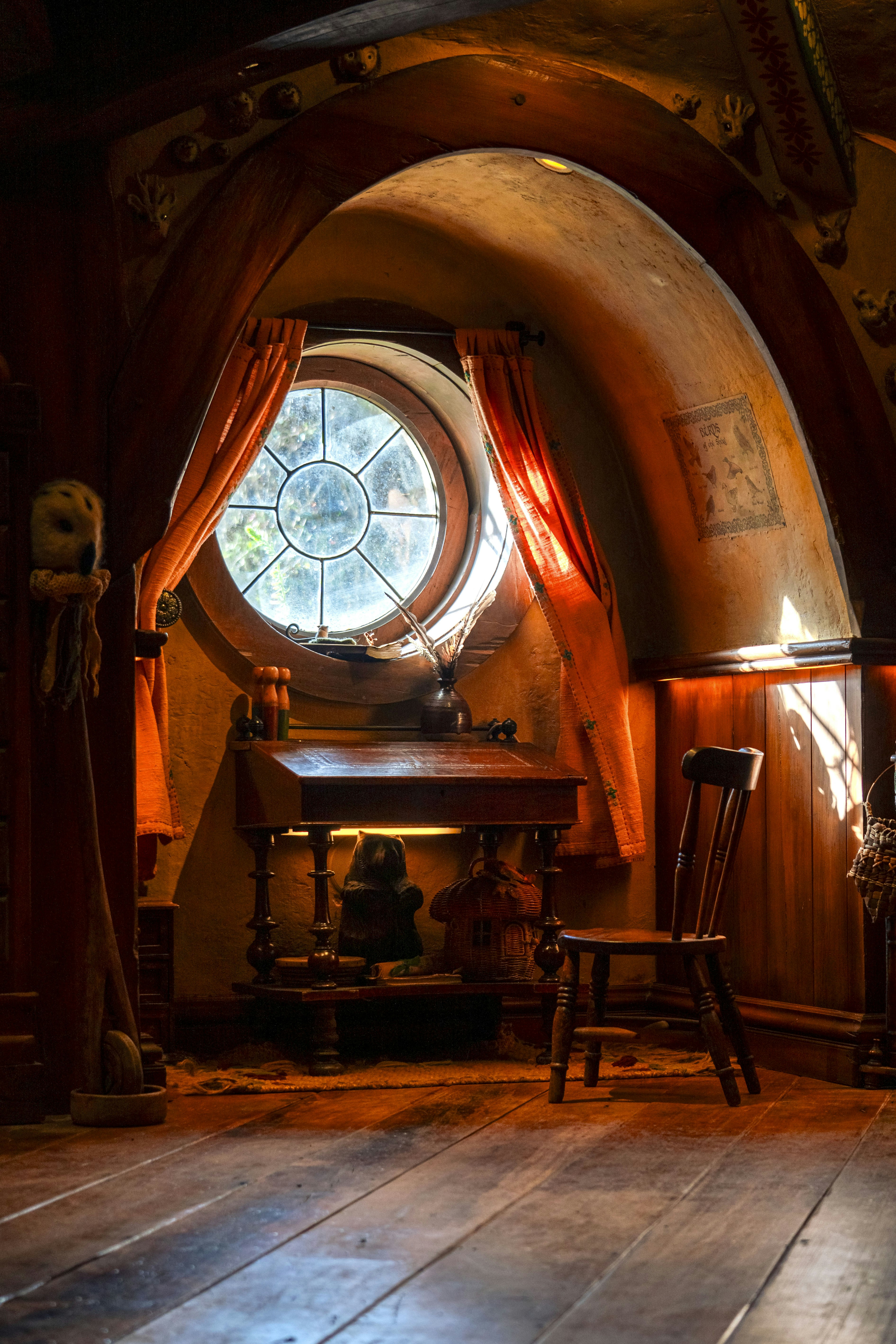 Ein Zimmer mit einem runden Fenster und einem Holzboden