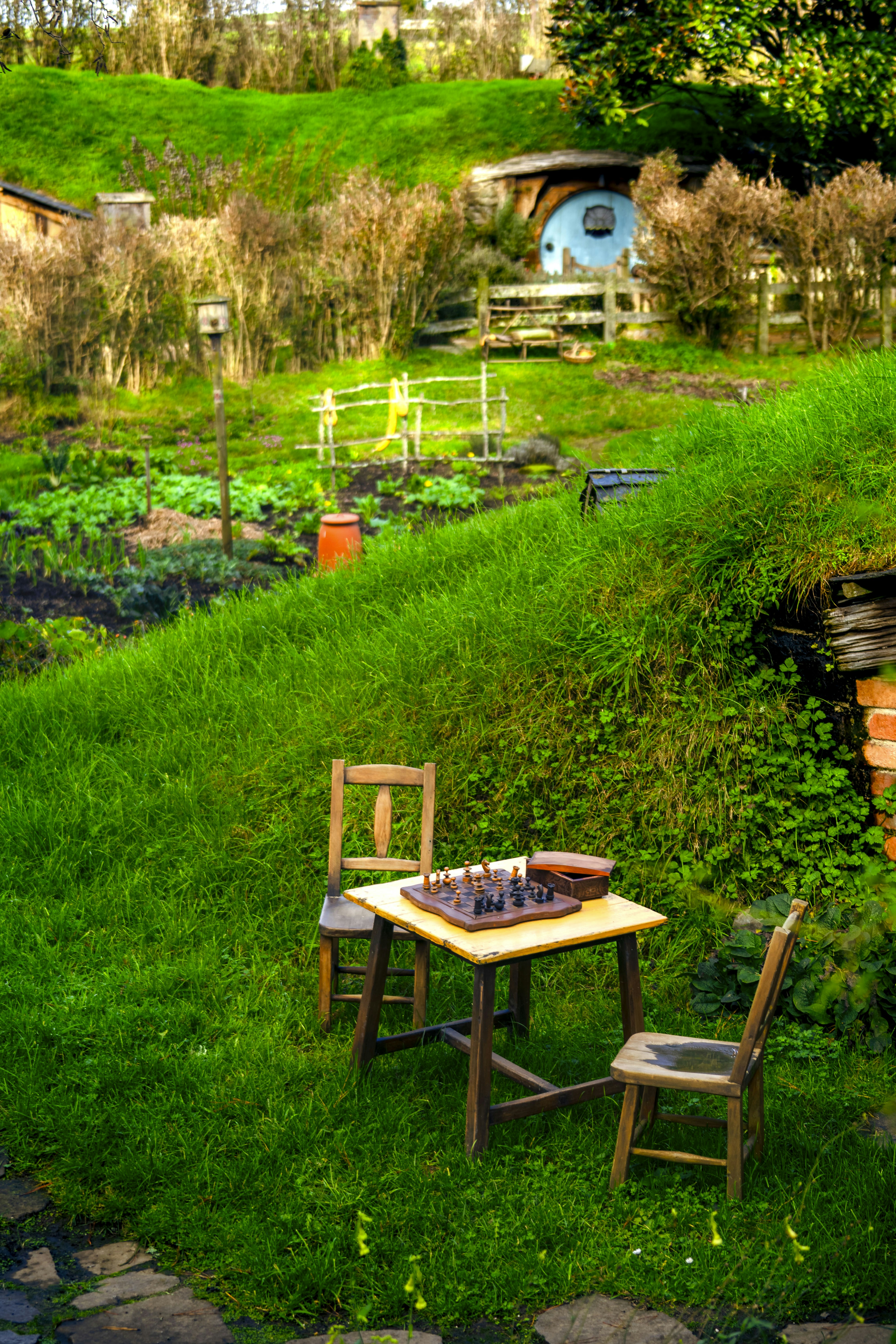 A table and chairs in the grass near a hobbot