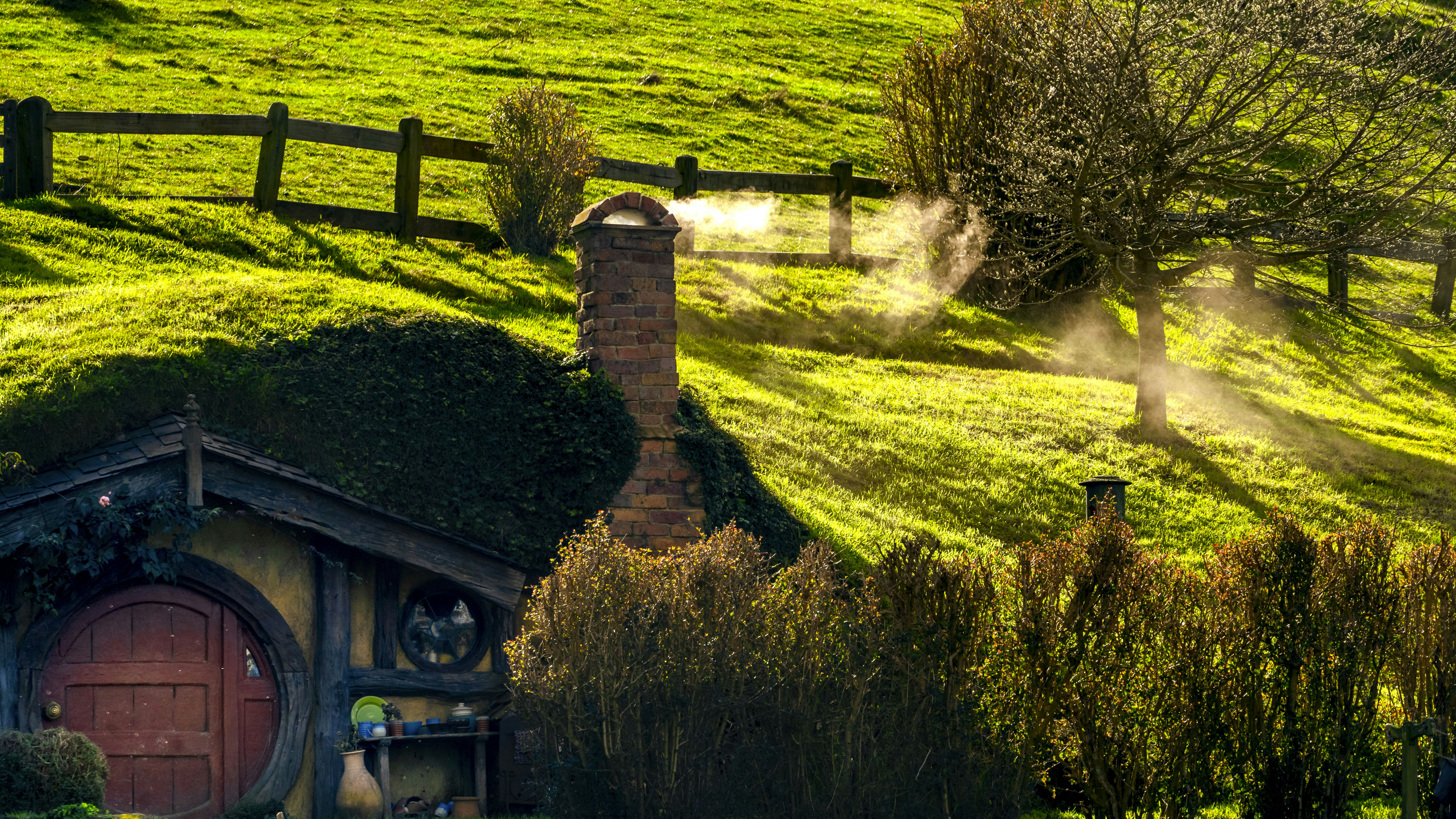 Ein kleines Haus mit grünem Dach auf einem Feld