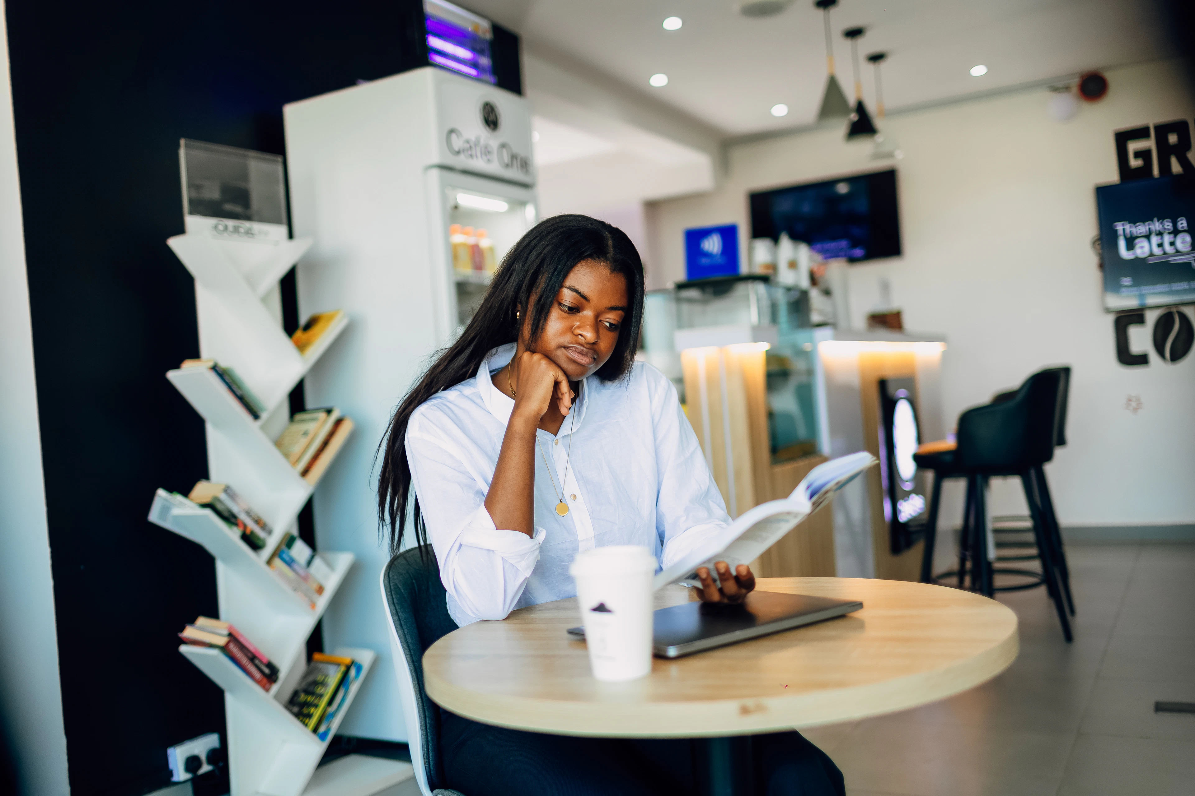 A woman reading a book at a café in Lagos, Nigeria