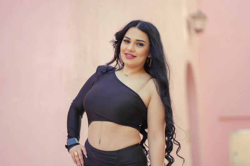 curvy woman in black dress posing confidently