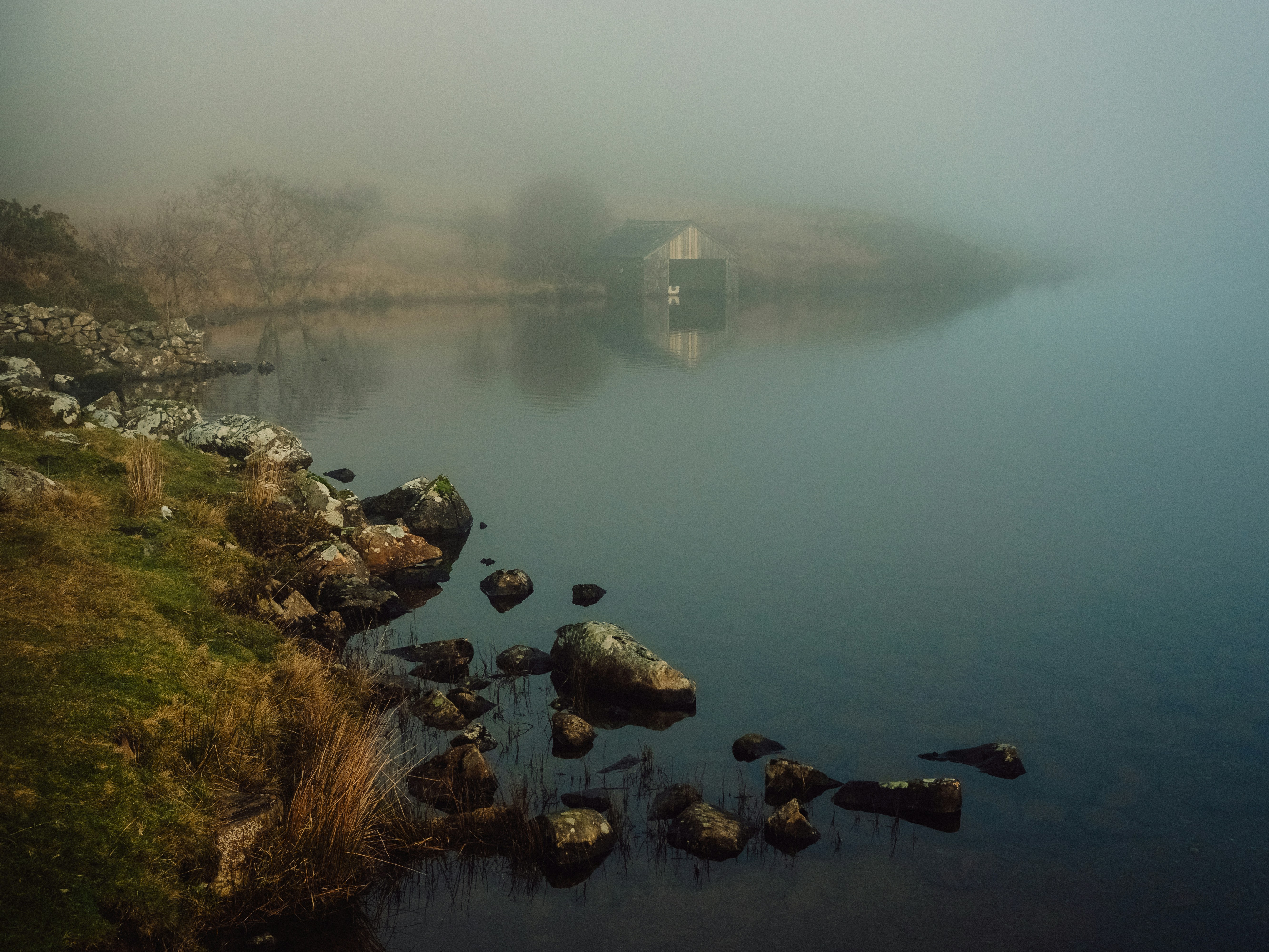 A body of water surrounded by grass and rocks