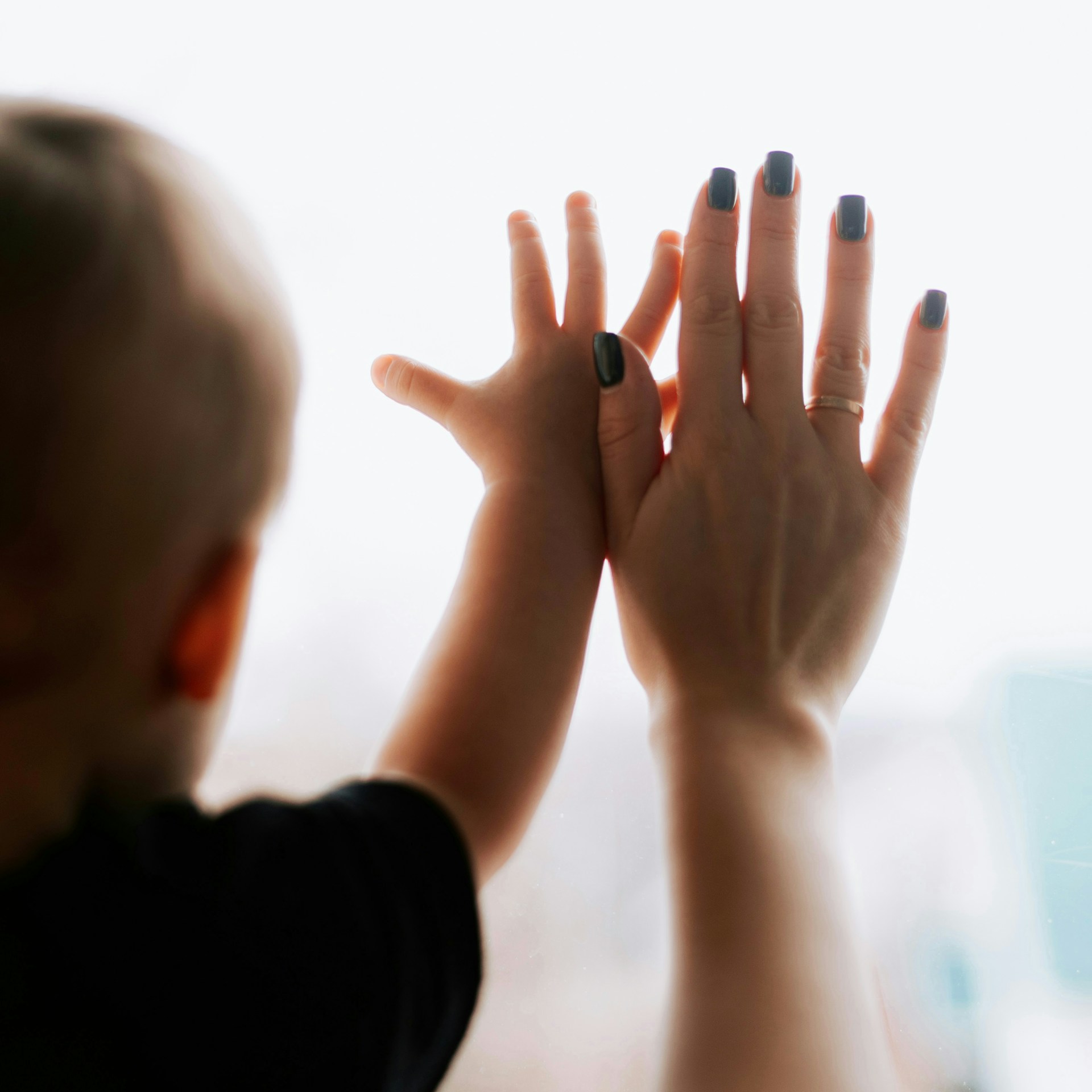 A woman holding her hands up in front of a window