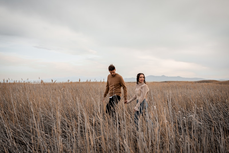A man and a woman walking through a field