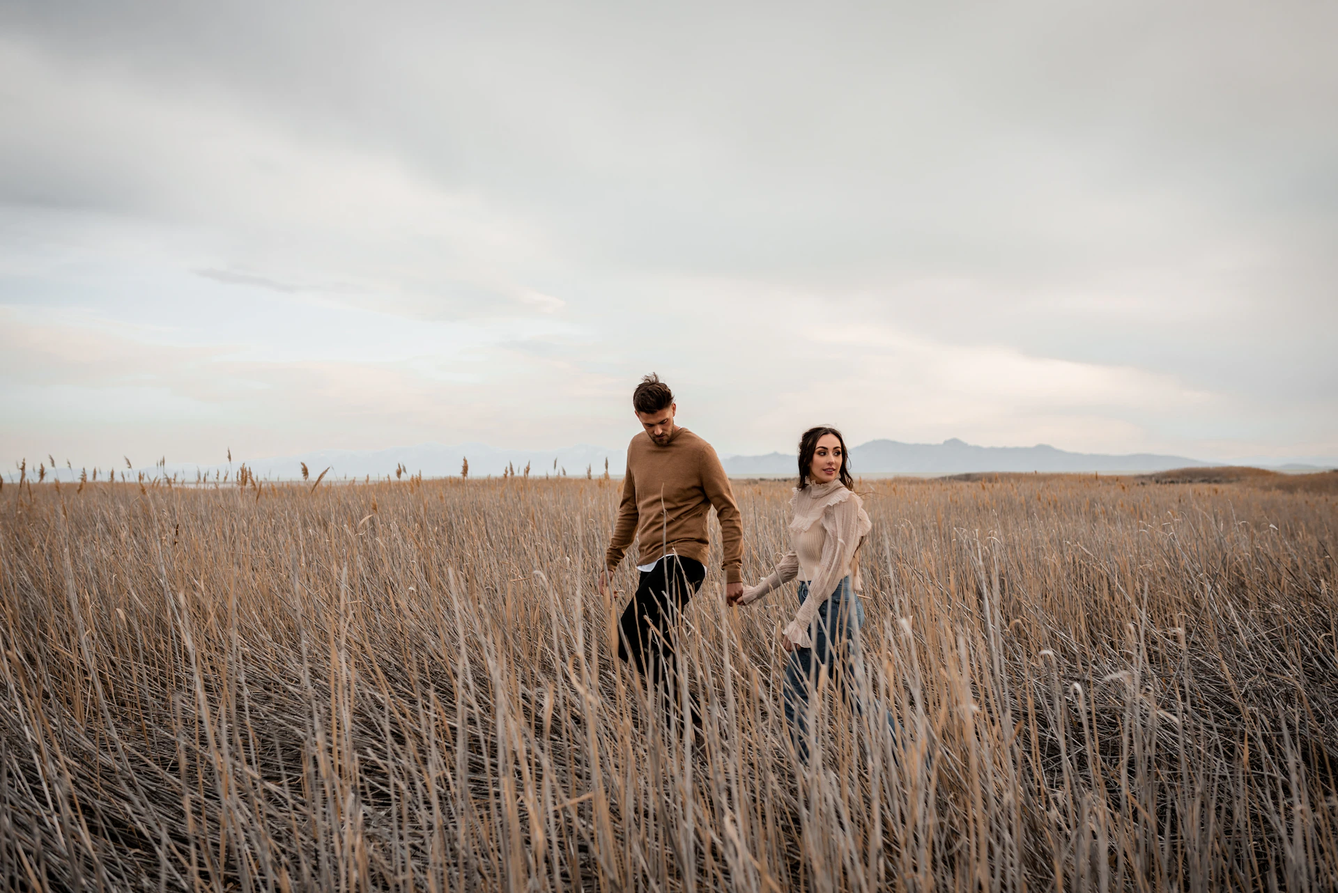 A man and a woman walking through a field