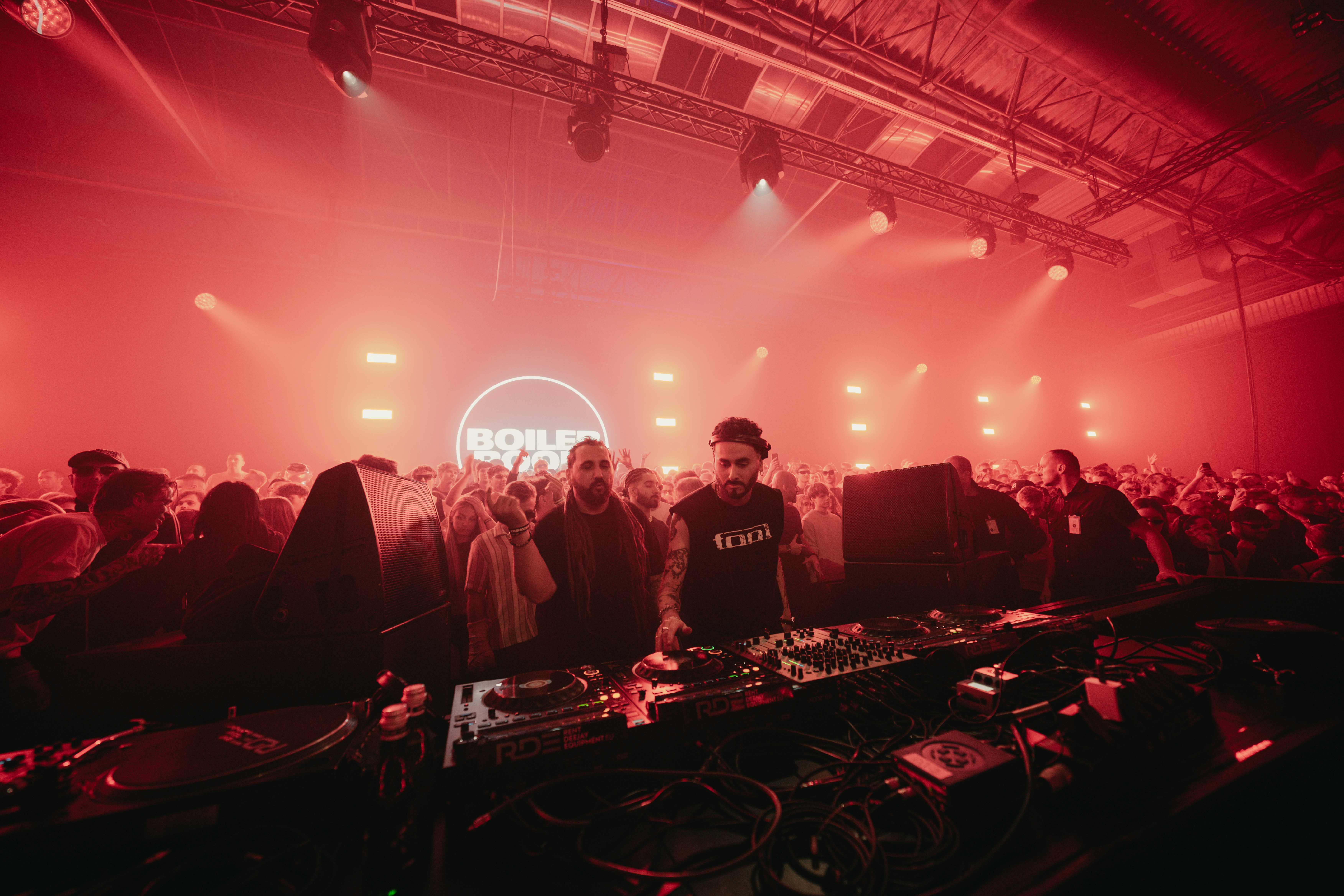 A group of people that are standing in front of some dj's