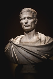 A bust of a man with a cape around his neck