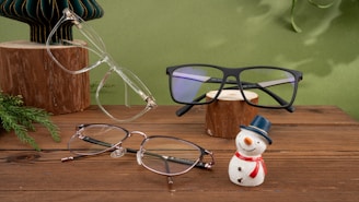 A wooden table topped with glasses and a snowman figurine