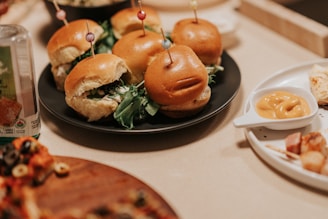 A table topped with plates filled with mini hamburgers