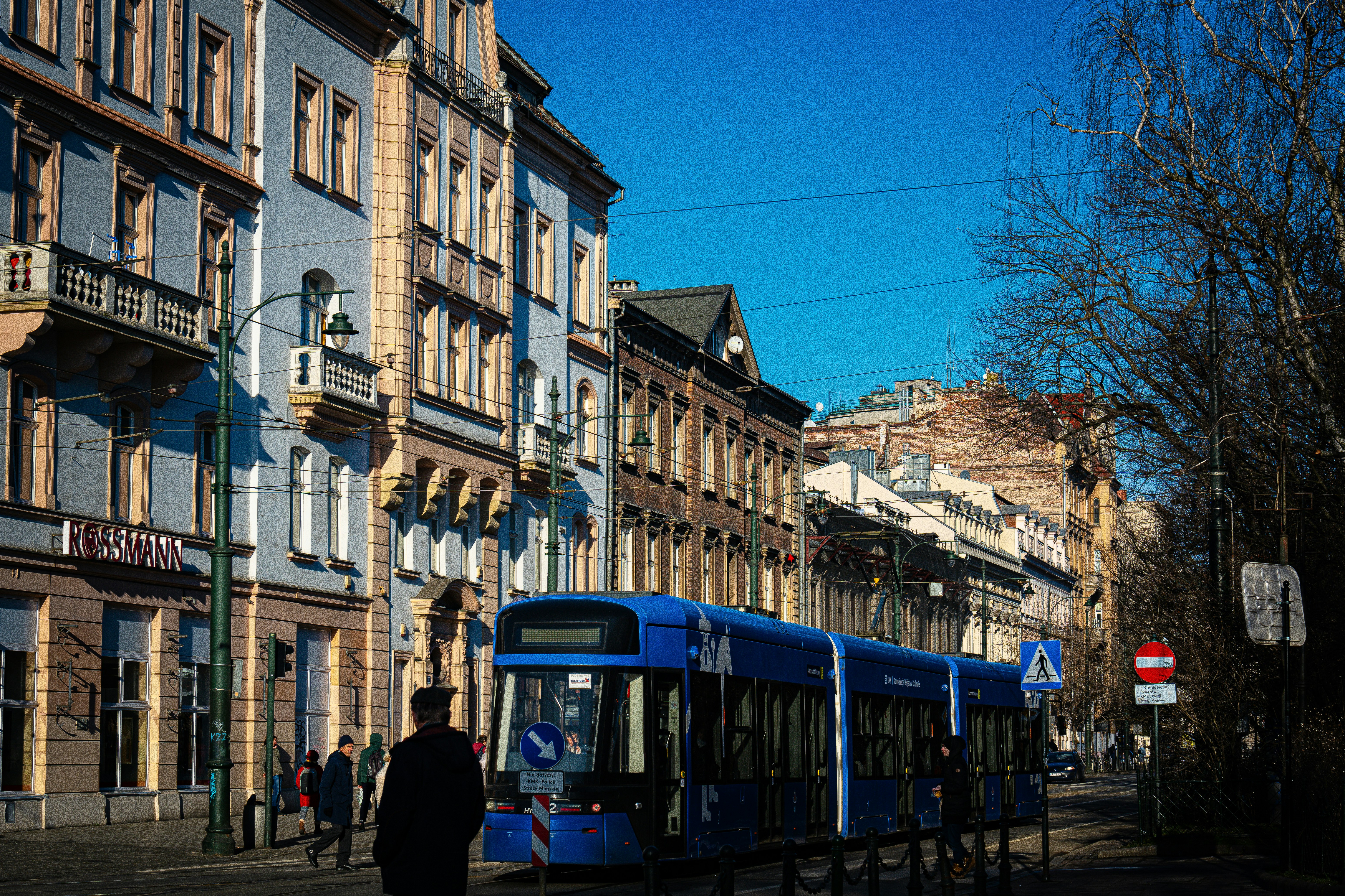 A blue and white bus parked on the side of a road