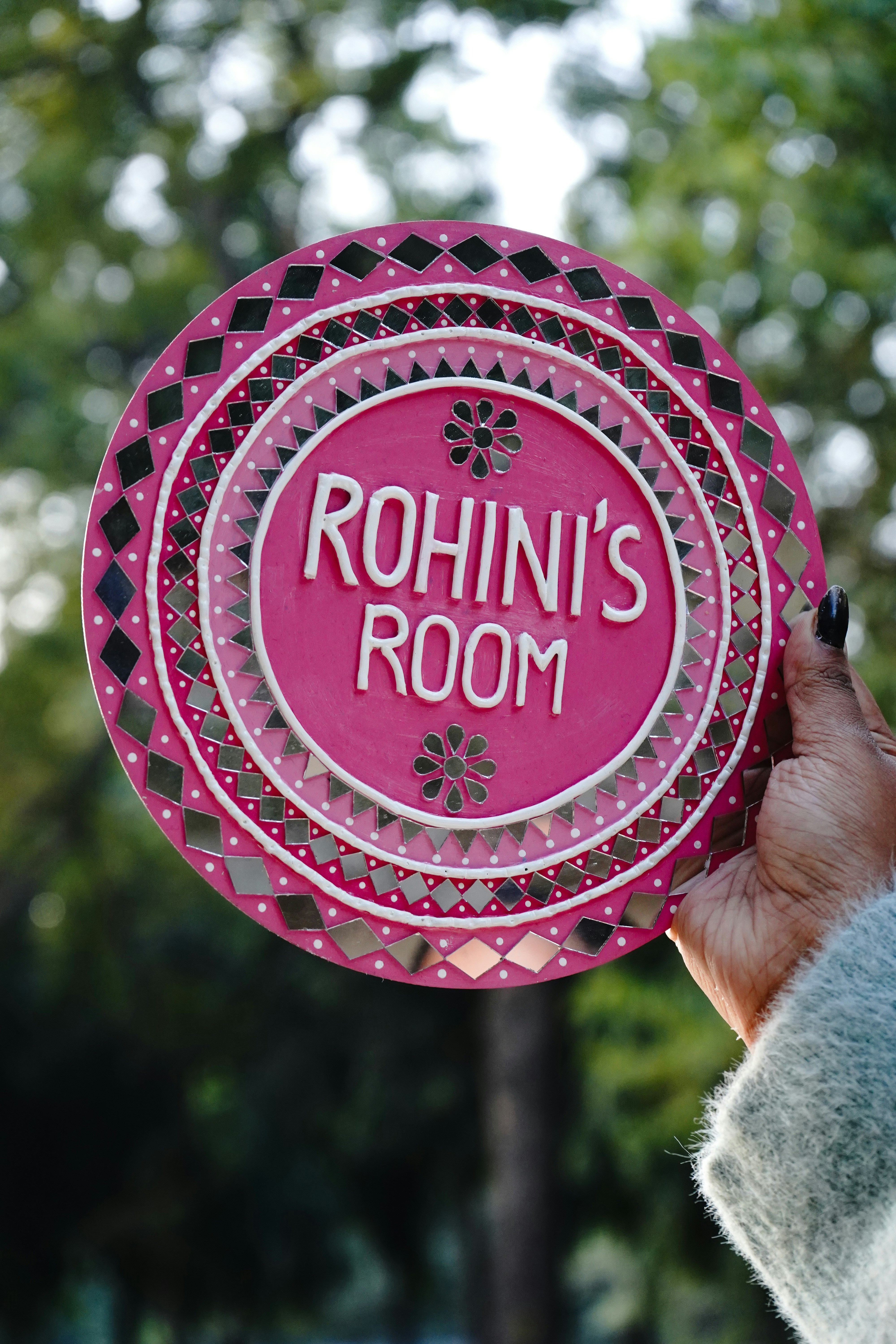 A person holding a sign that says rohn's room