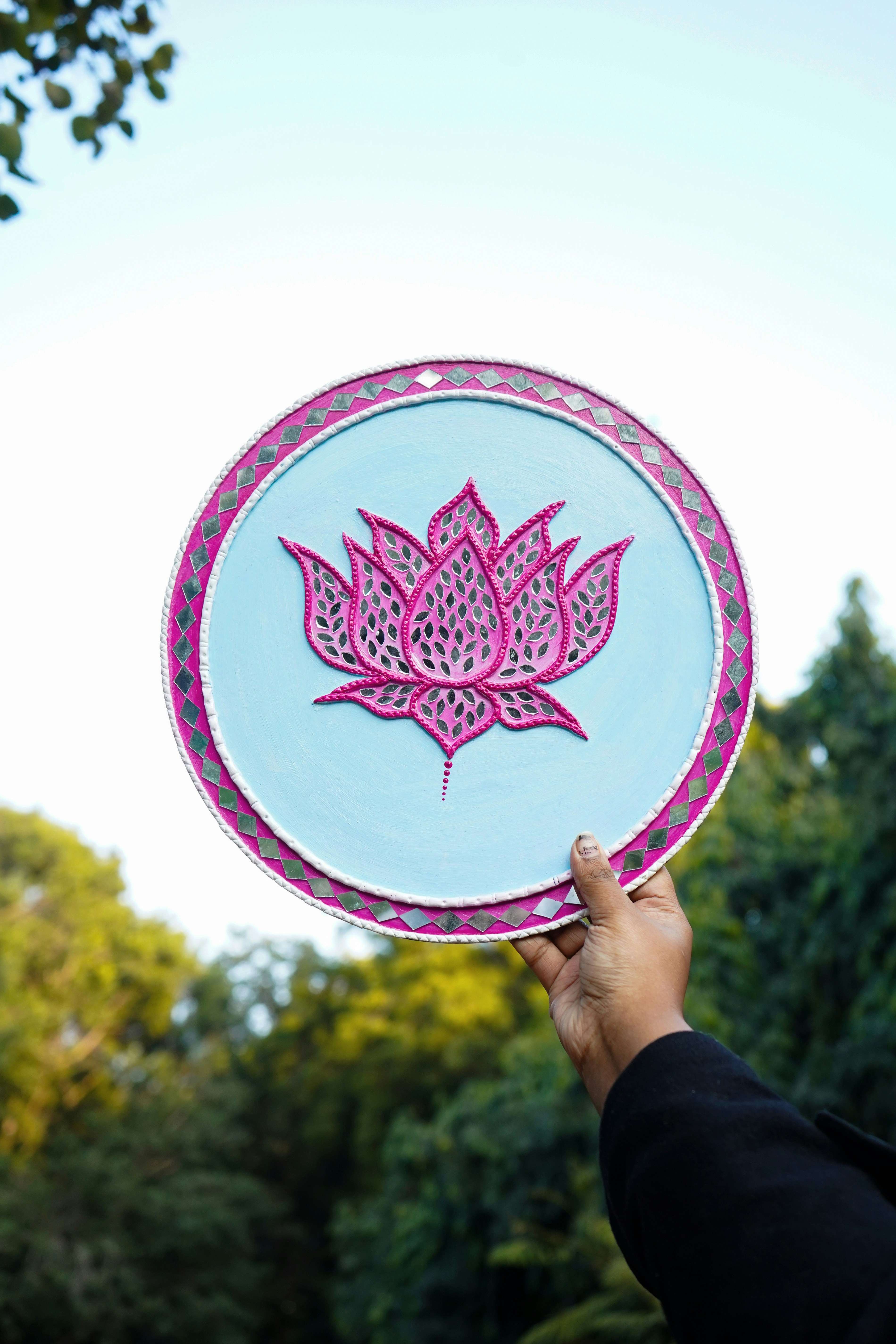 A person holding a paper plate with a pink flower on it
