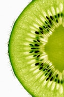A kiwi fruit cut in half on a white background