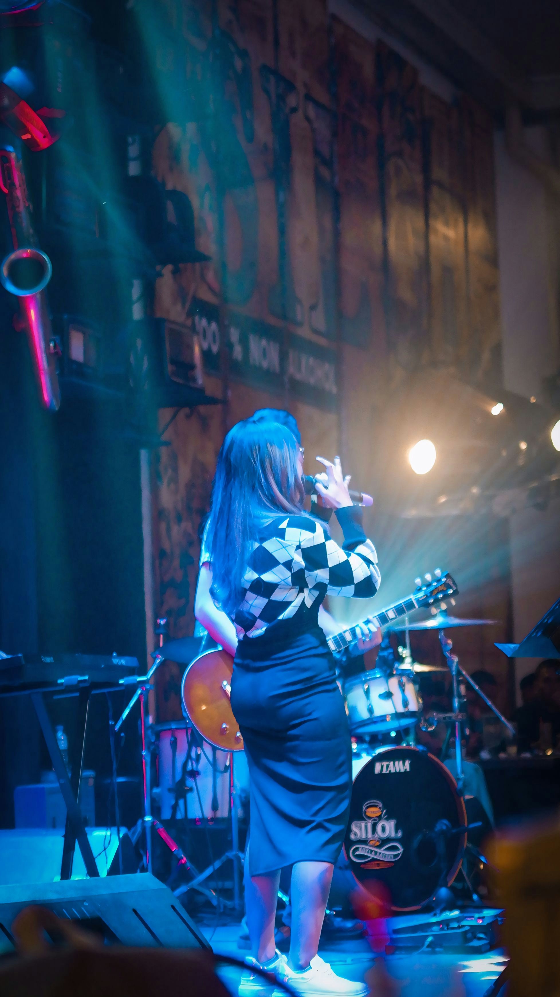 A woman standing on a stage singing into a microphone