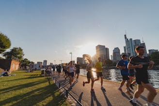 A group of people running down a street next to a river