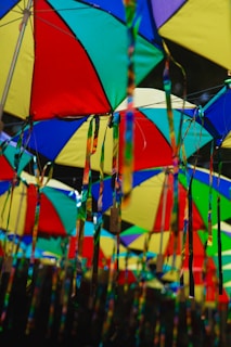 A group of multicolored umbrellas hanging from a ceiling