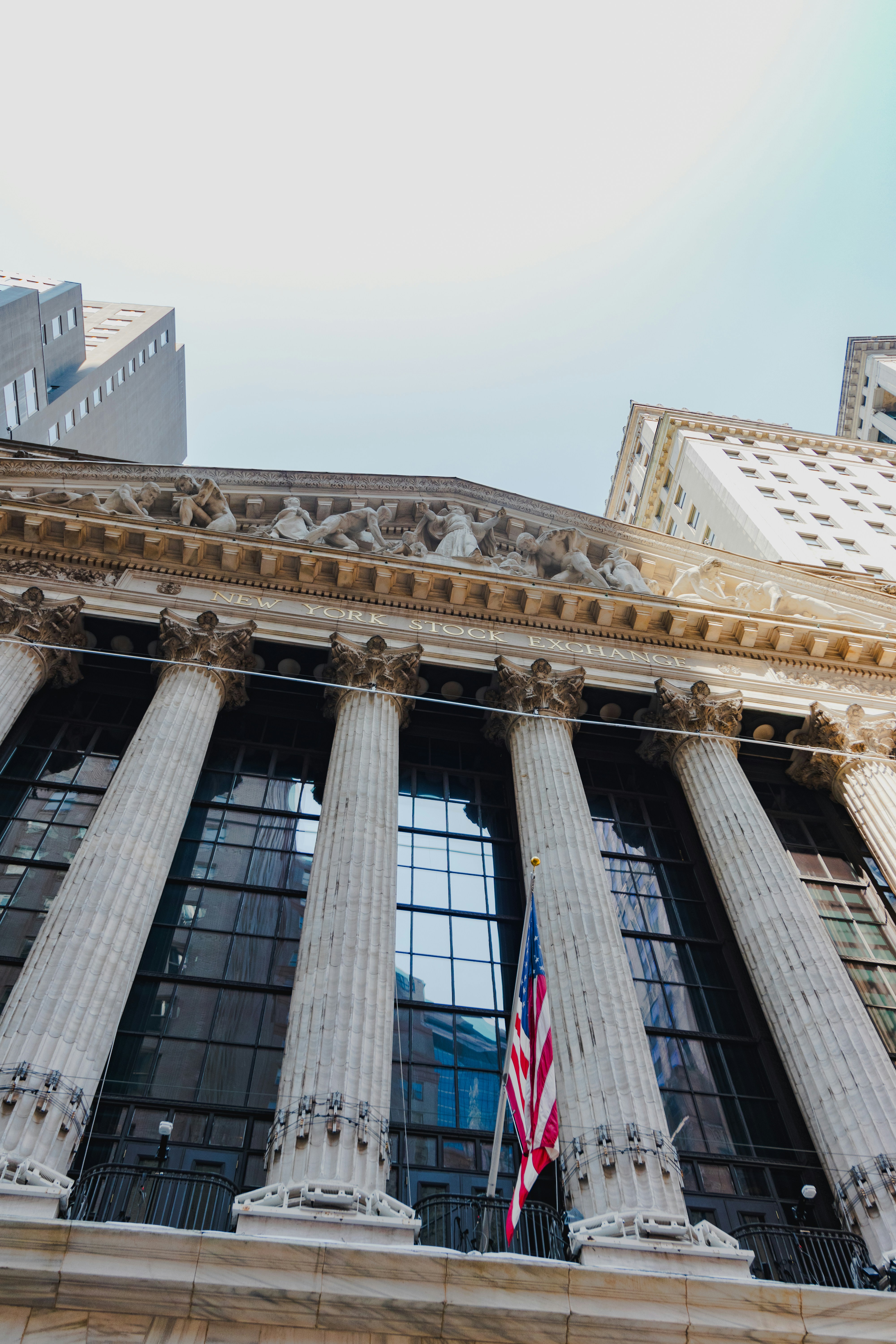 A tall building with columns and a flag on top of it