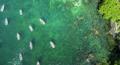 A group of boats floating on top of a body of water
