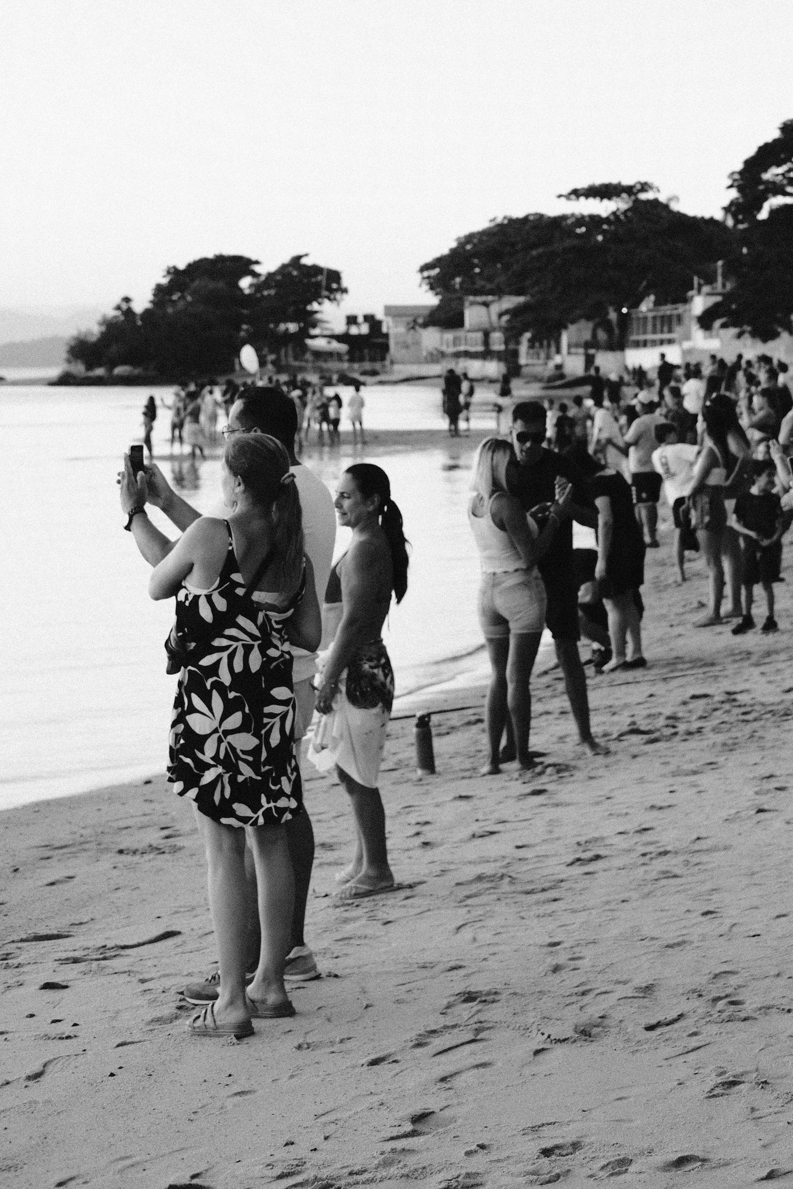 A group of people standing on top of a sandy beach