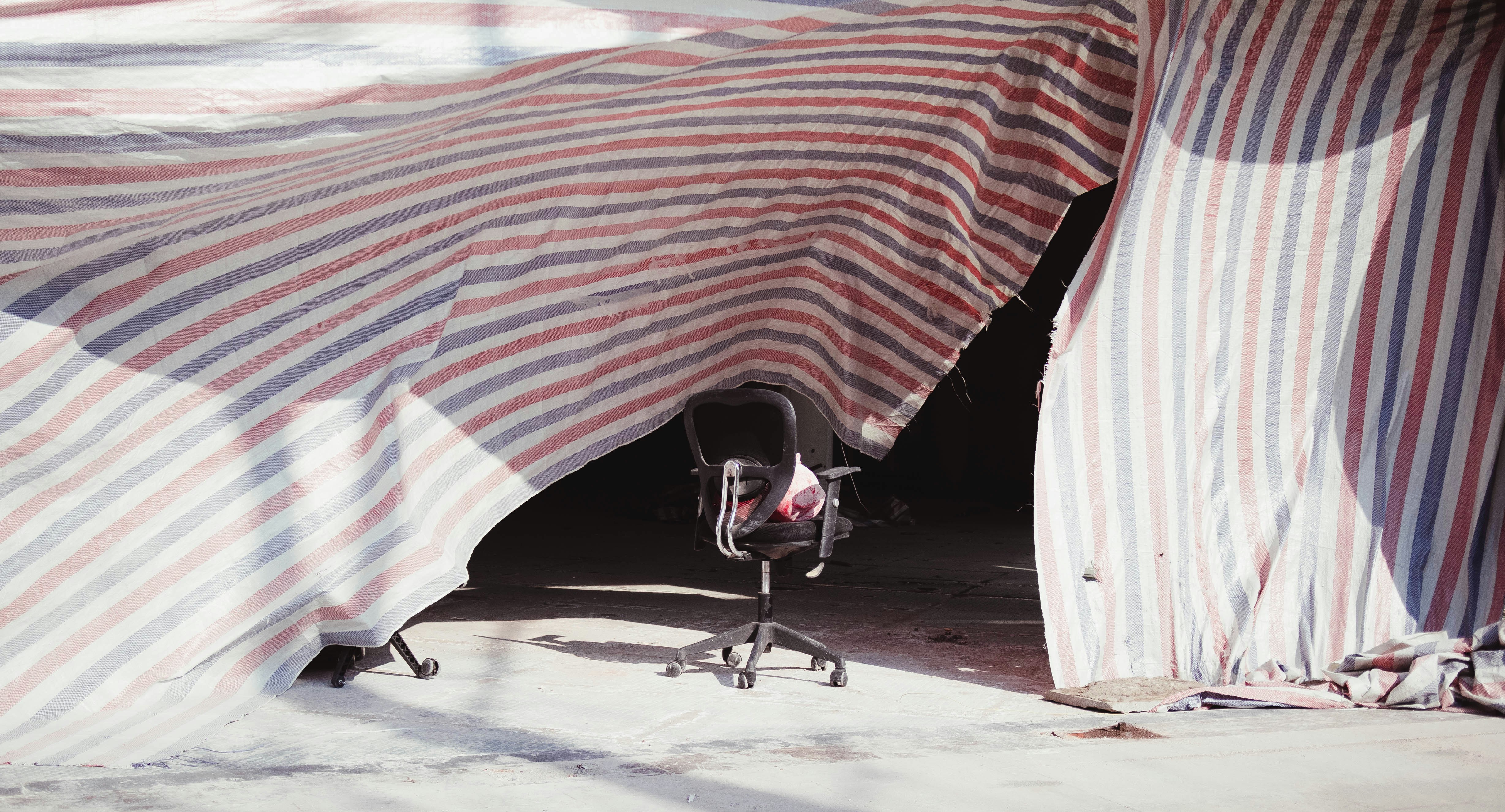 A chair under an umbrella on a sunny day