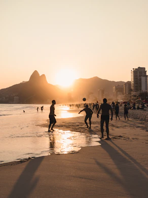 A group of people walking along a beach next to the ocean