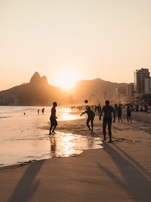 A group of people walking along a beach next to the ocean