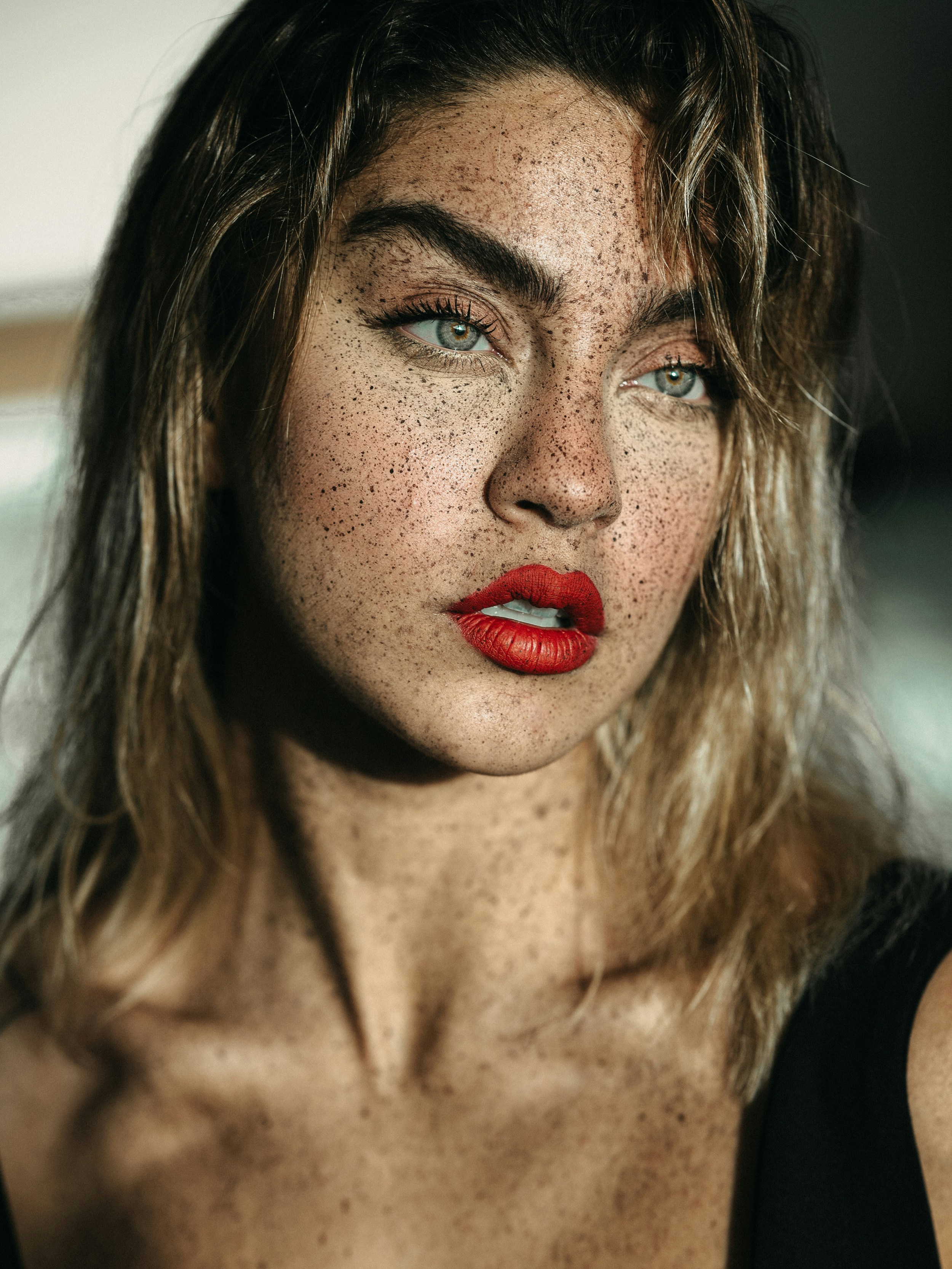 A woman with freckled hair and red lipstick