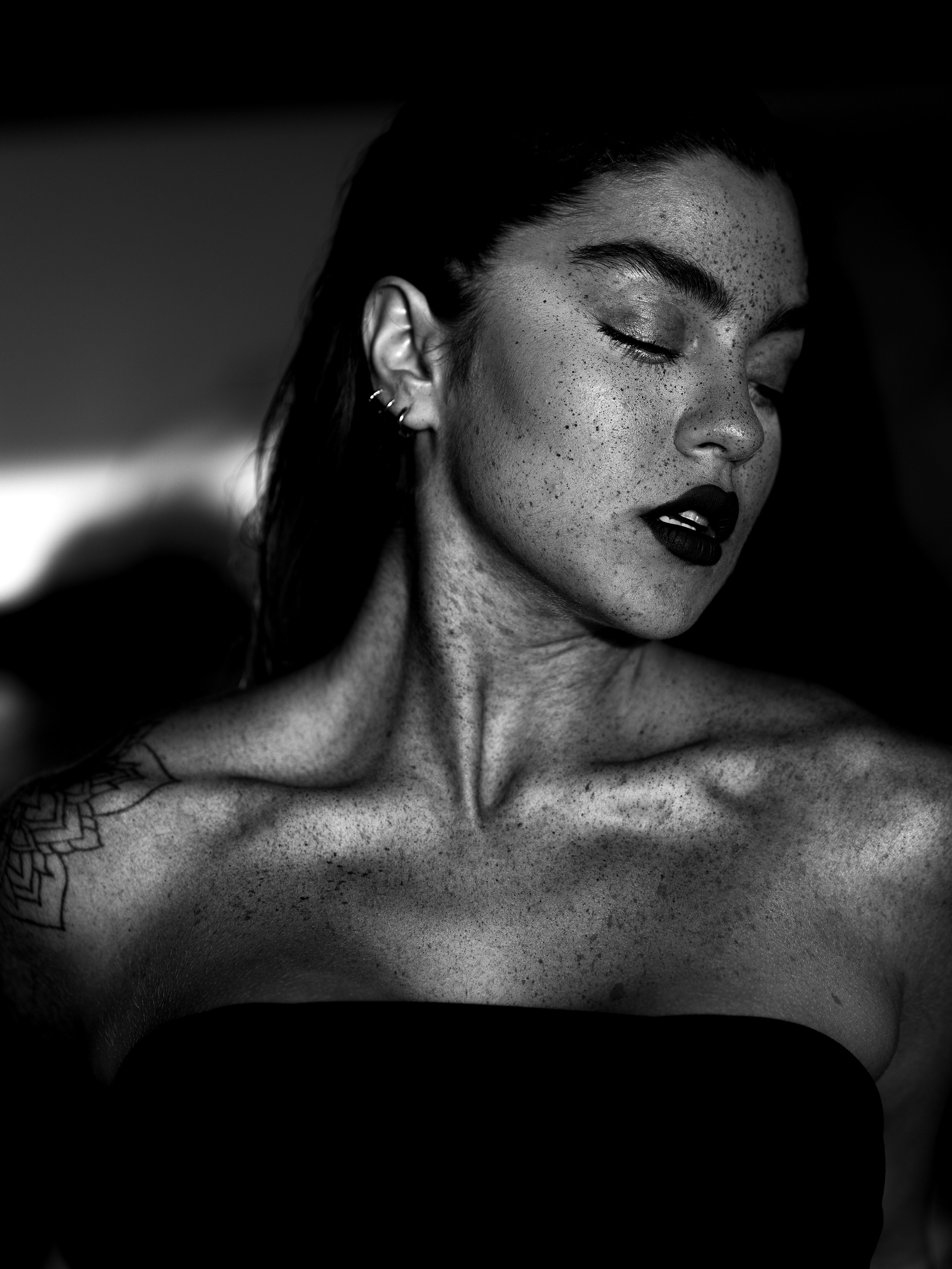 A woman in a strapless top with her eyes closed