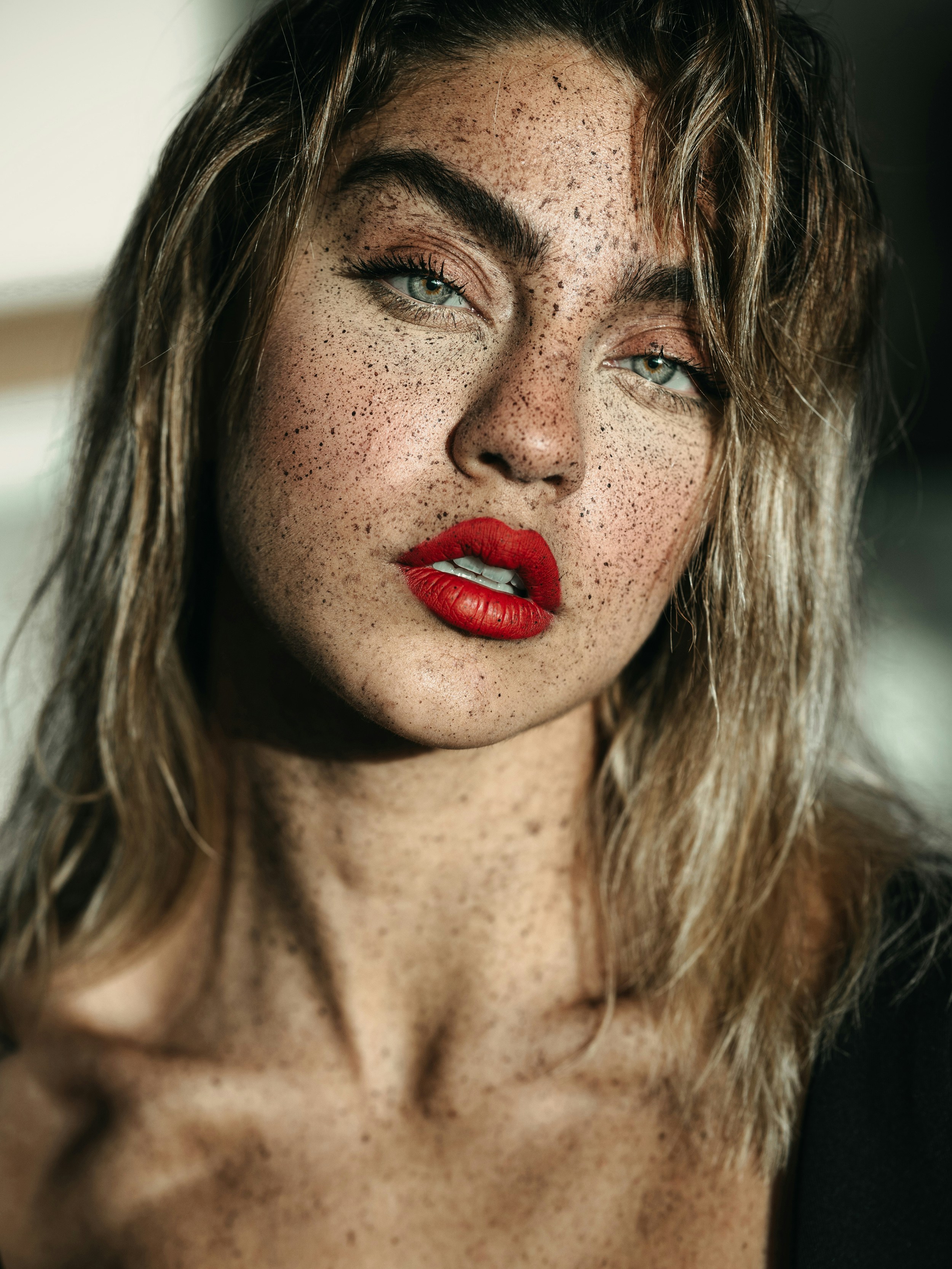 A woman with freckled hair and red lipstick