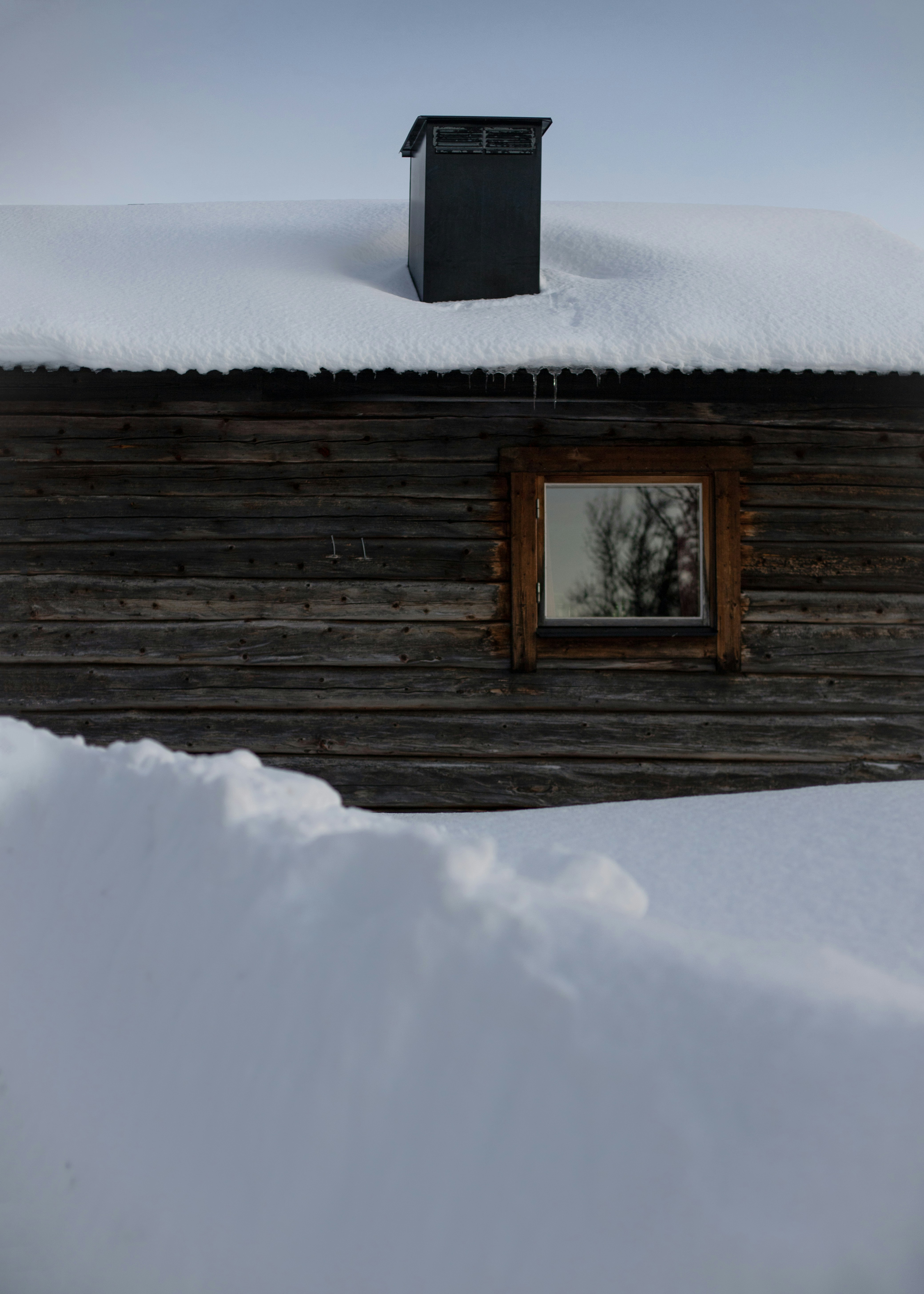 Une cabane en rondins avec de la neige sur le toit