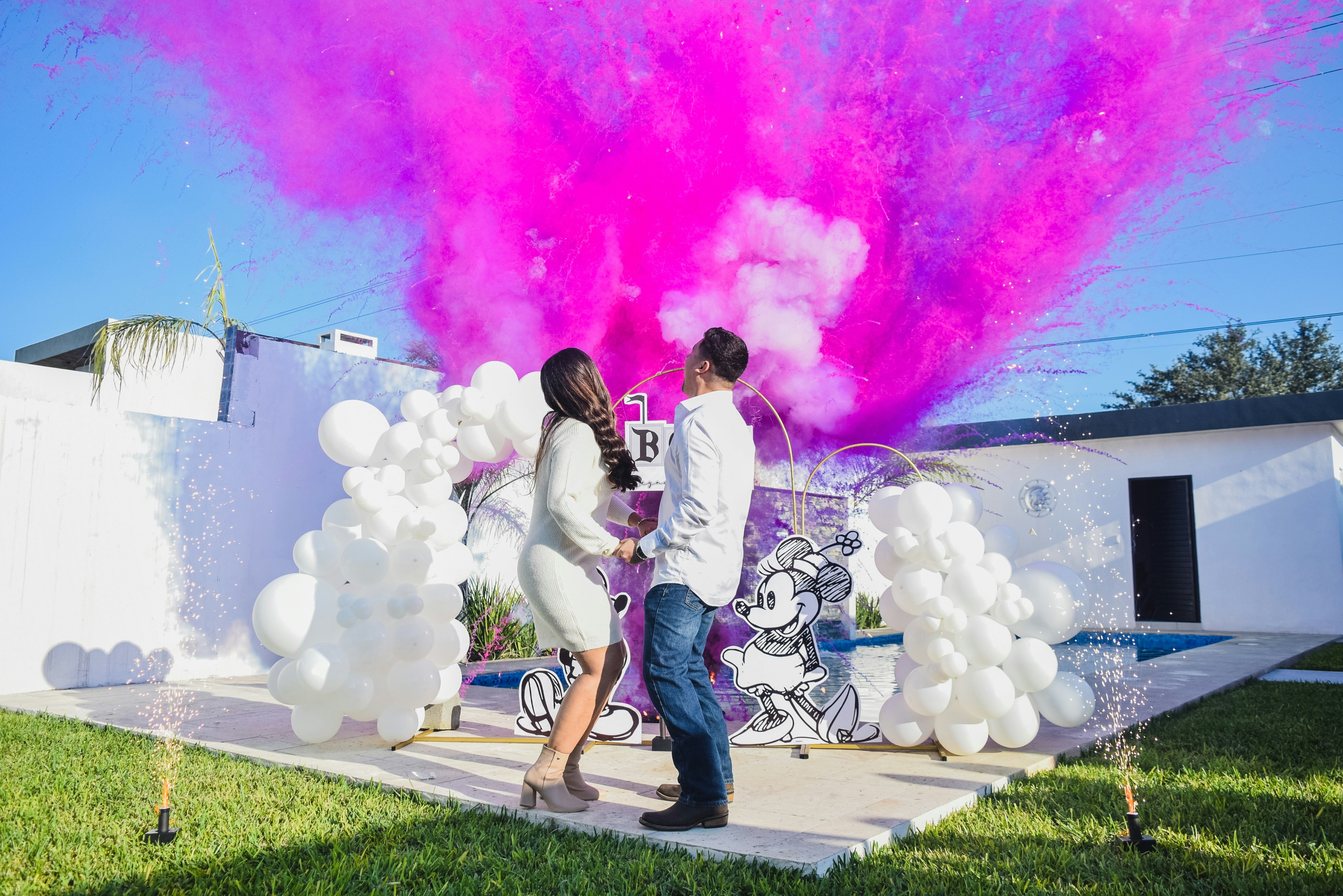 A man and a woman standing in front of a building with colored powder