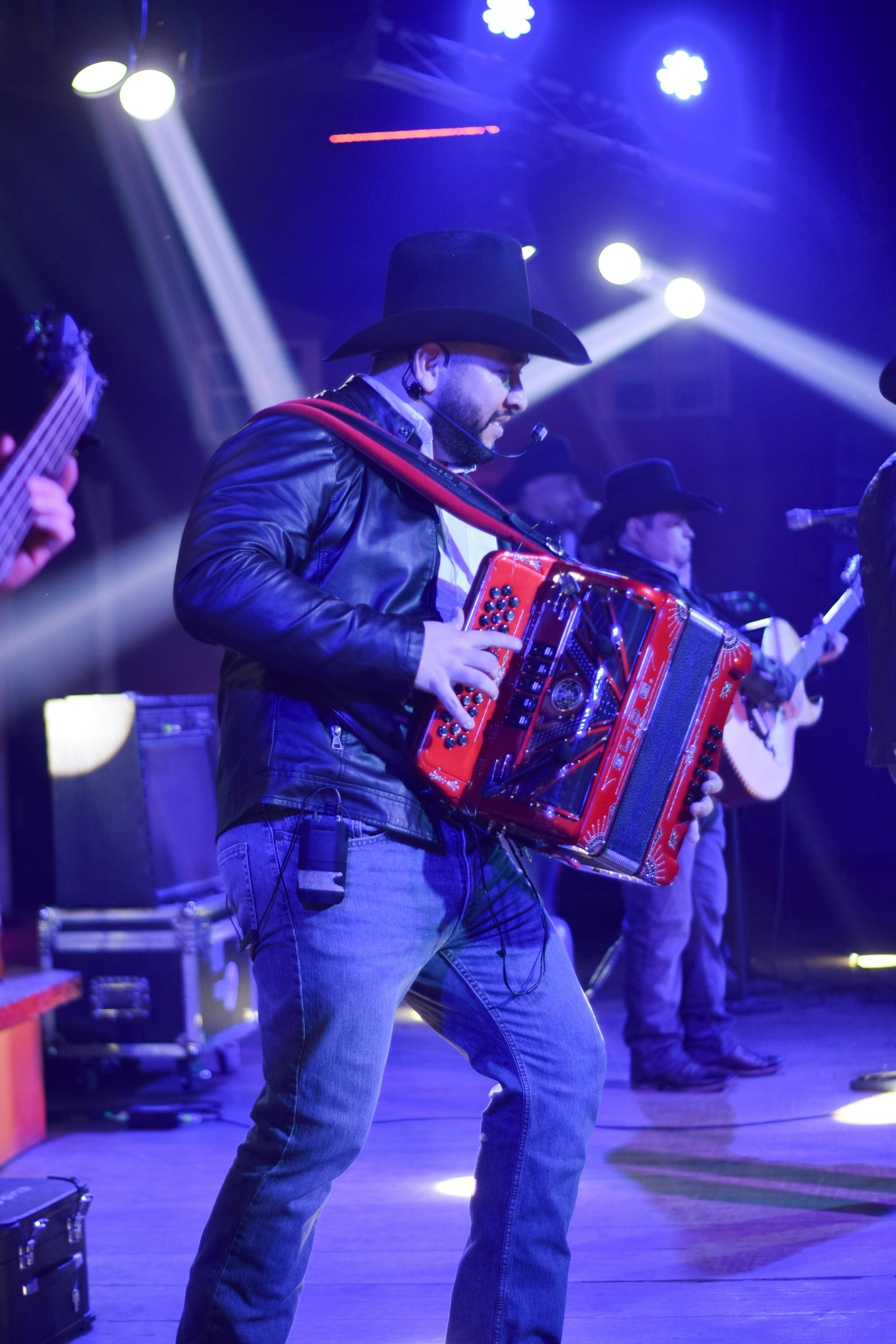 A man playing an accordion on stage at a concert