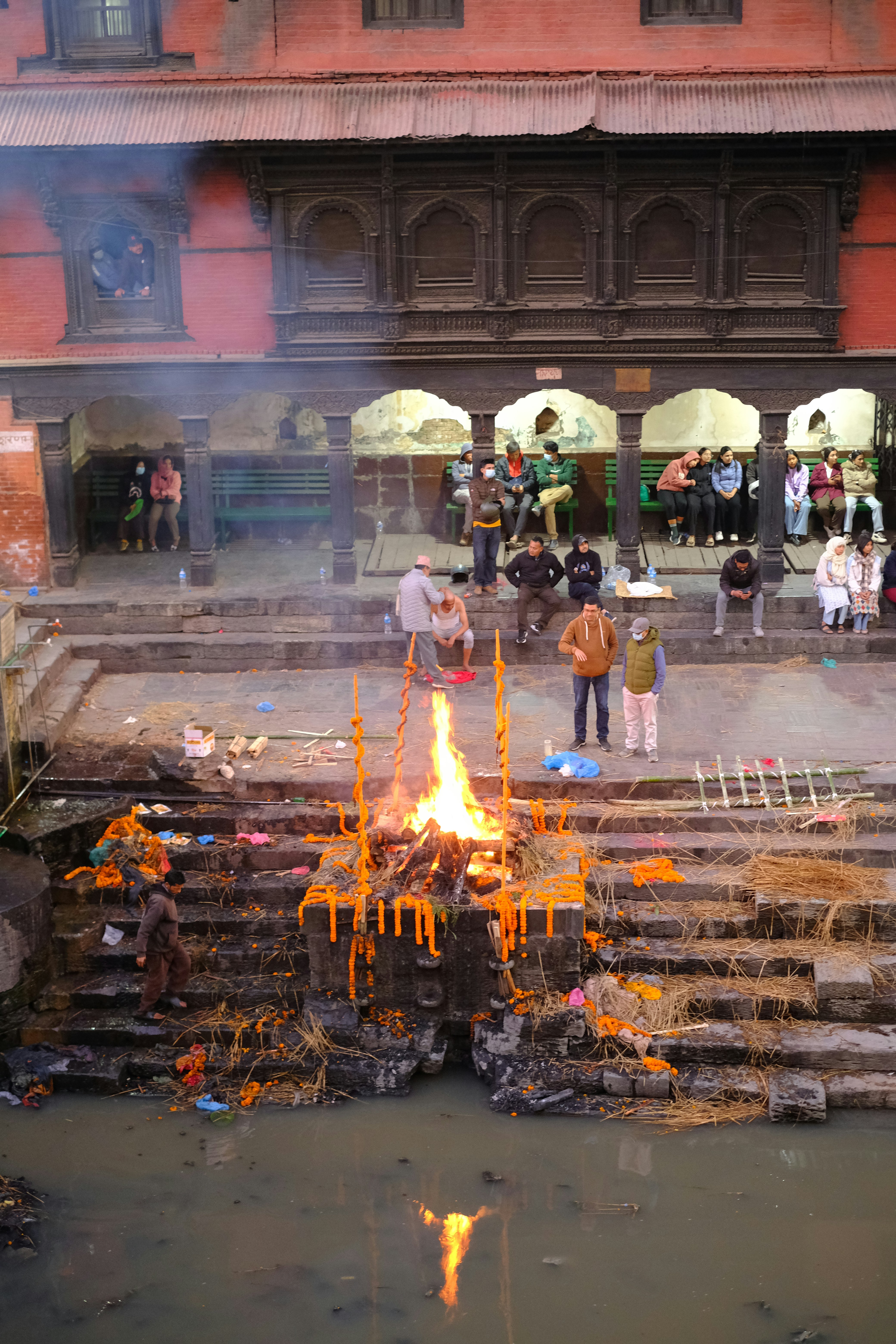 A group of people standing around a fire pit