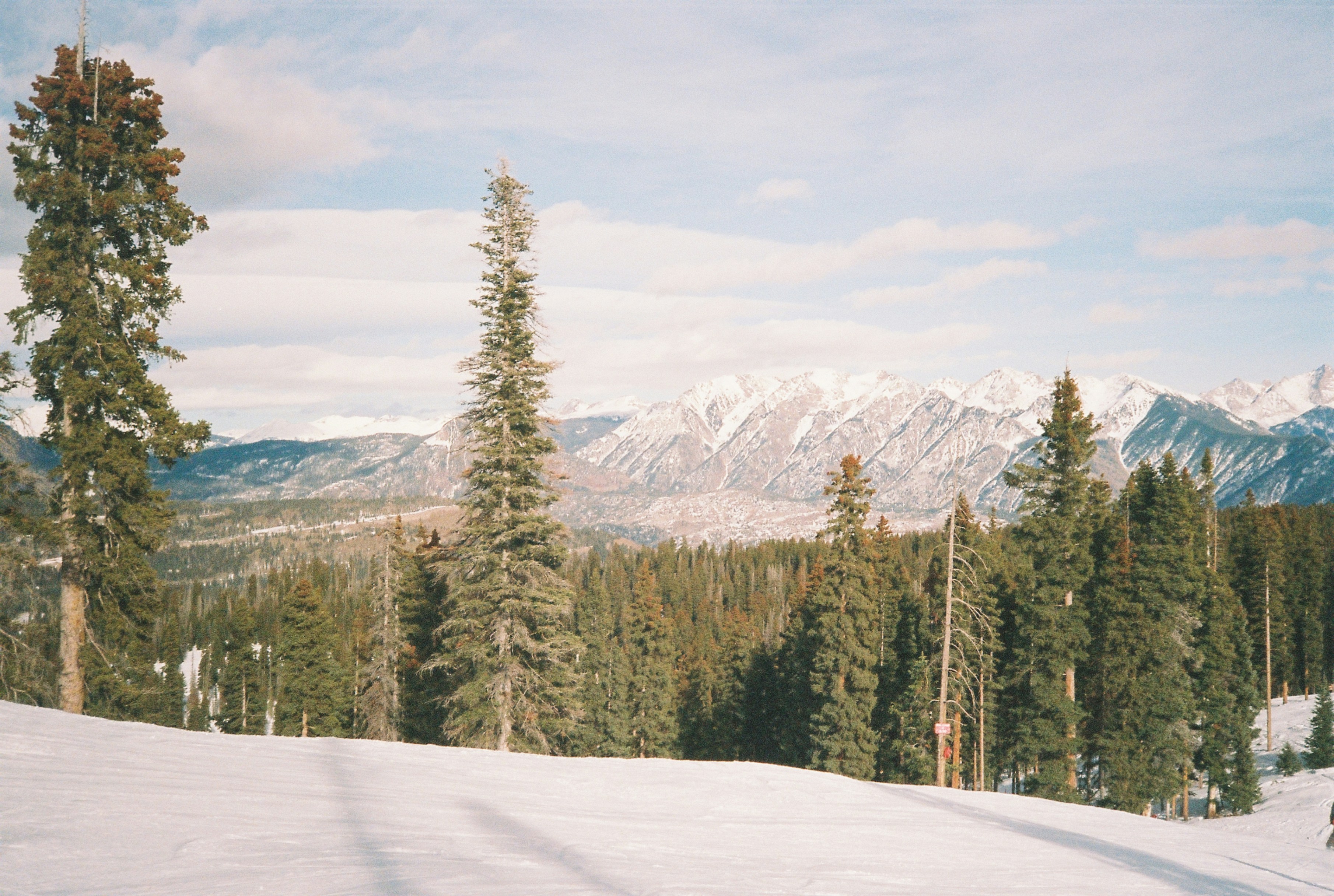 A man riding skis on top of a snow covered slope, 