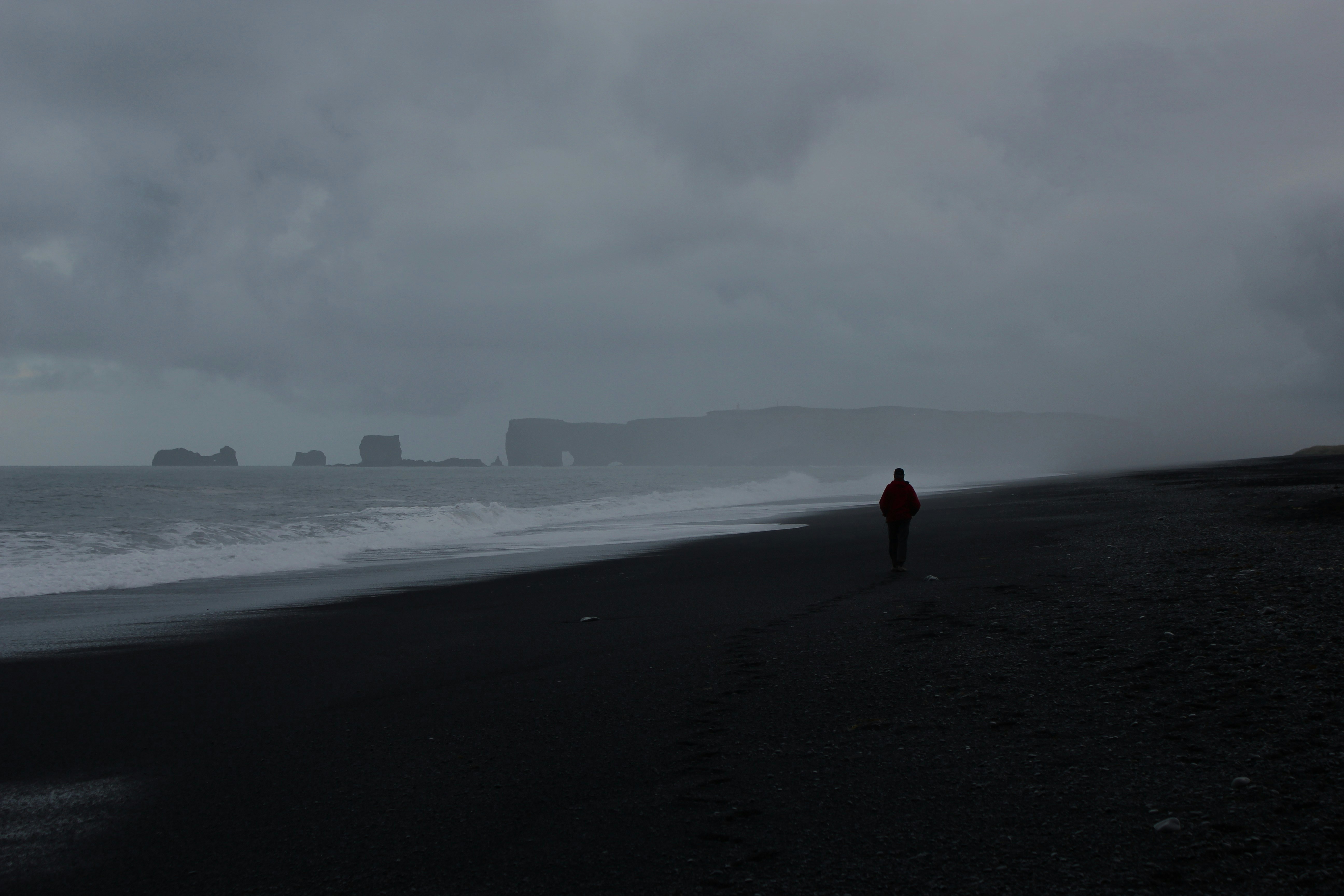 A person walking on a beach near the ocean