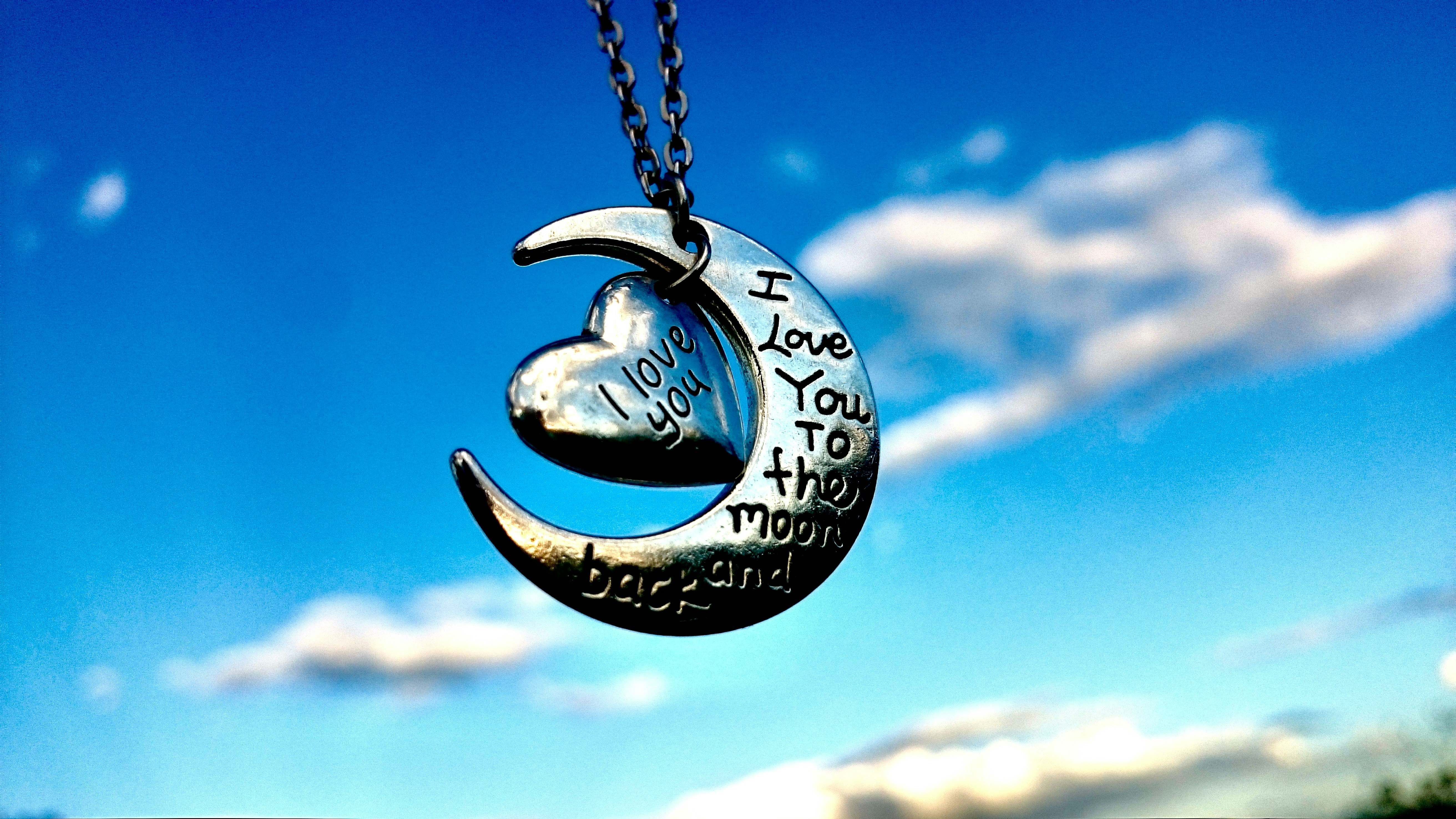 A crescent with a heart hanging from it