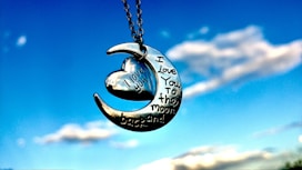 A crescent with a heart hanging from it